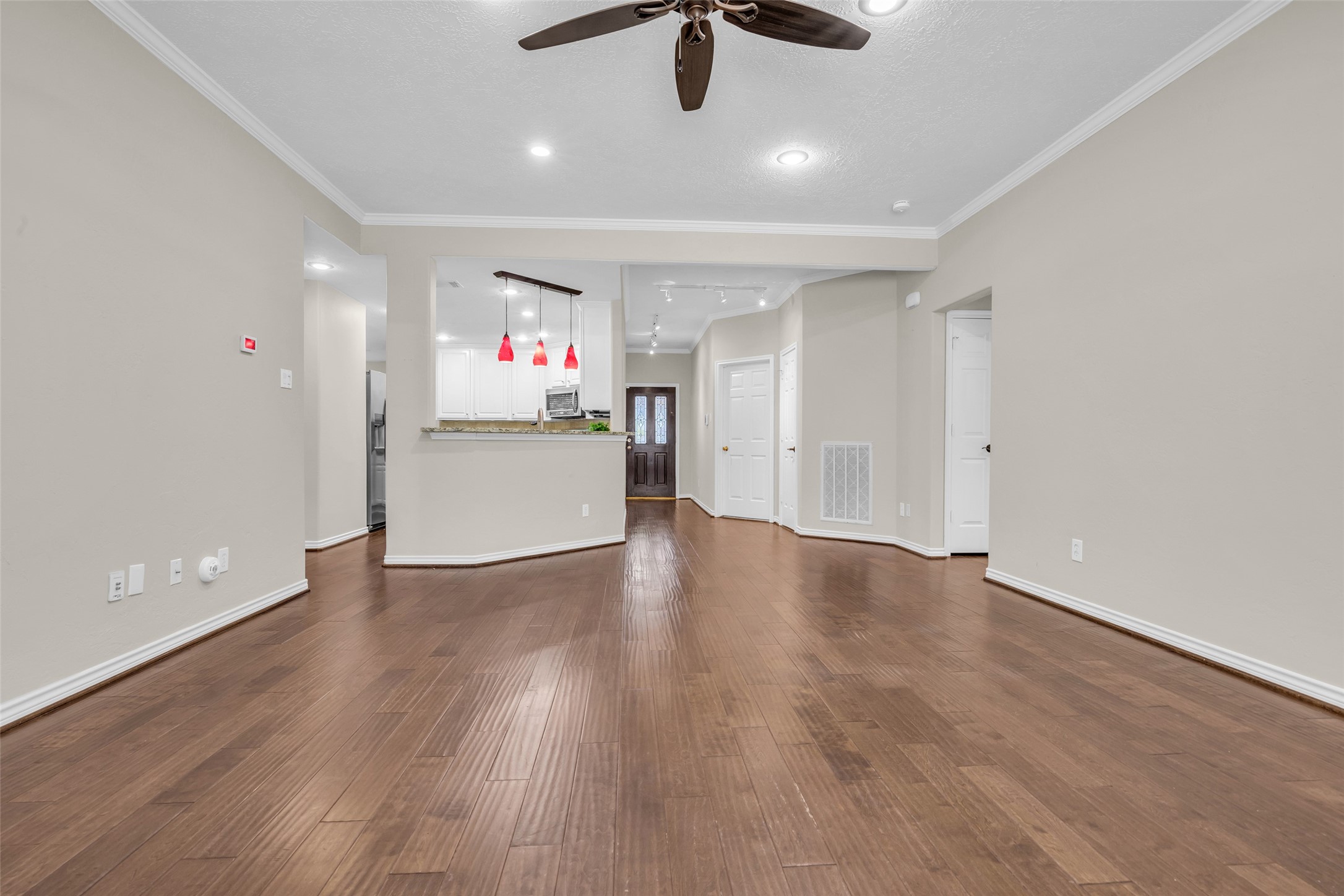 Split floor plan where the primary suite is located on the kitchen side of the living area.  The other two bedrooms are located on the other side of the living area.