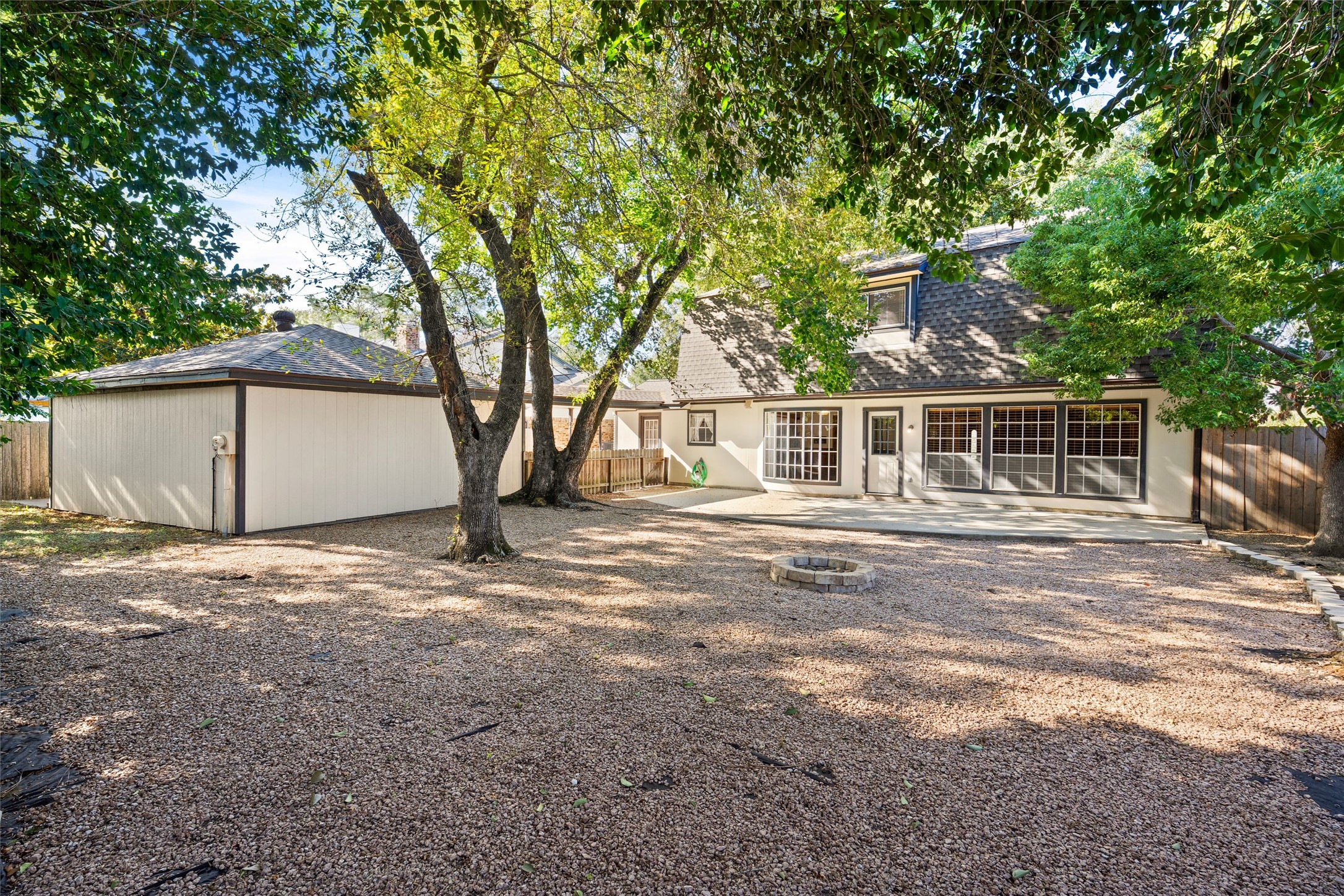 The backyard is easily maintained flanked only by flowerbeds and a large green space behind the detached garage.