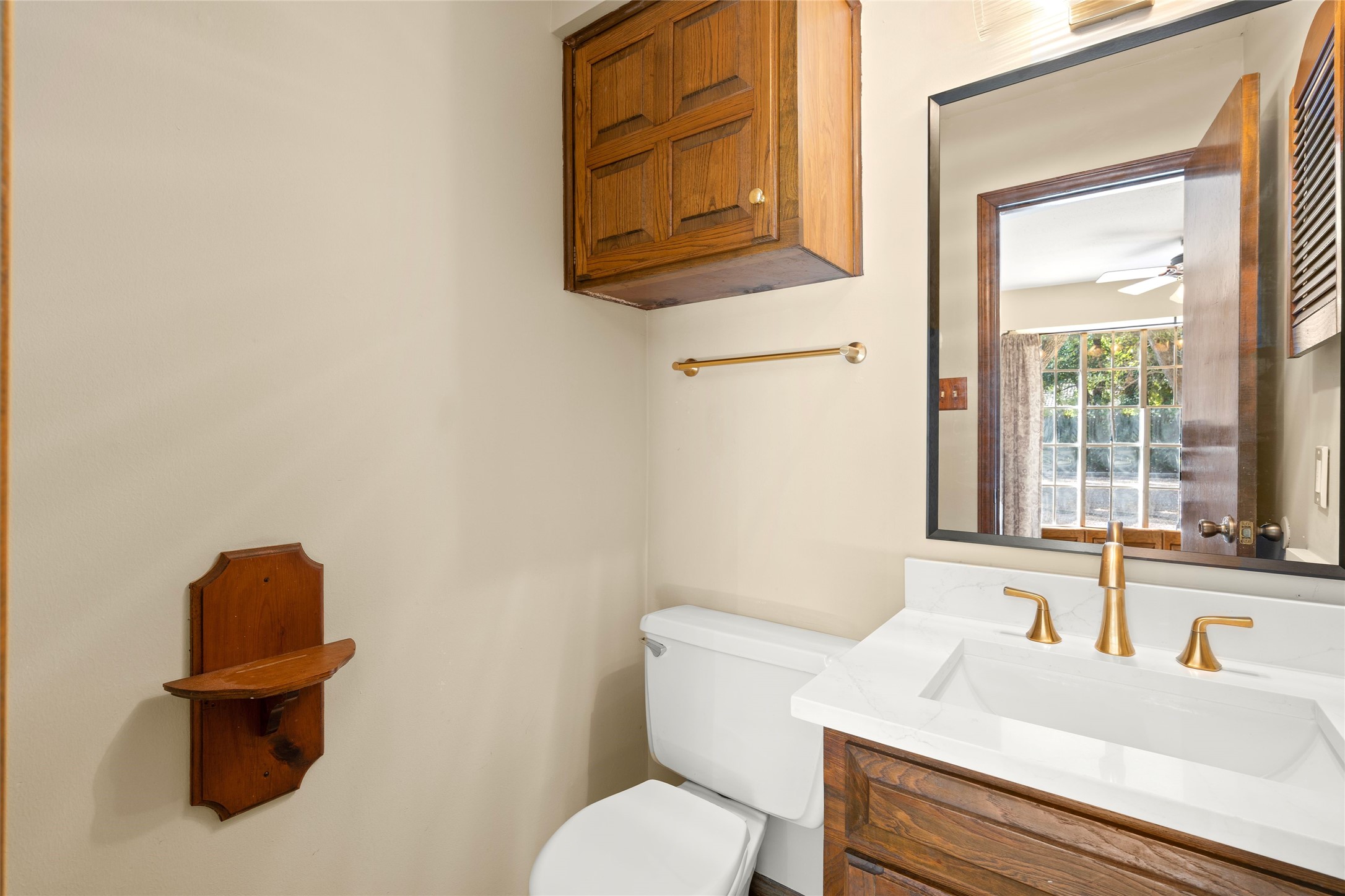 Half bath just off kitchen with new countertops, fixtures and rich cabinetry.