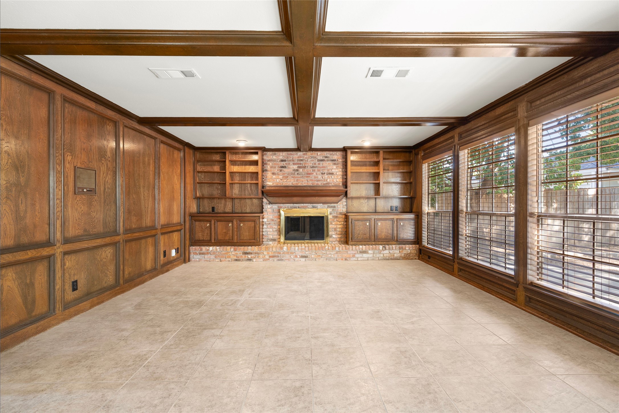 Rich wood beams accent the ceiling and present the brick hearth for a cozy feel.