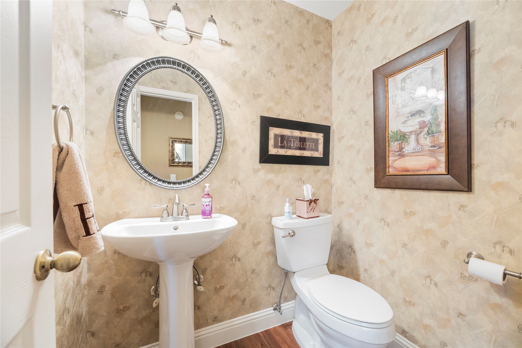 Convenient downstairs half bathroom with a pedestal sink.