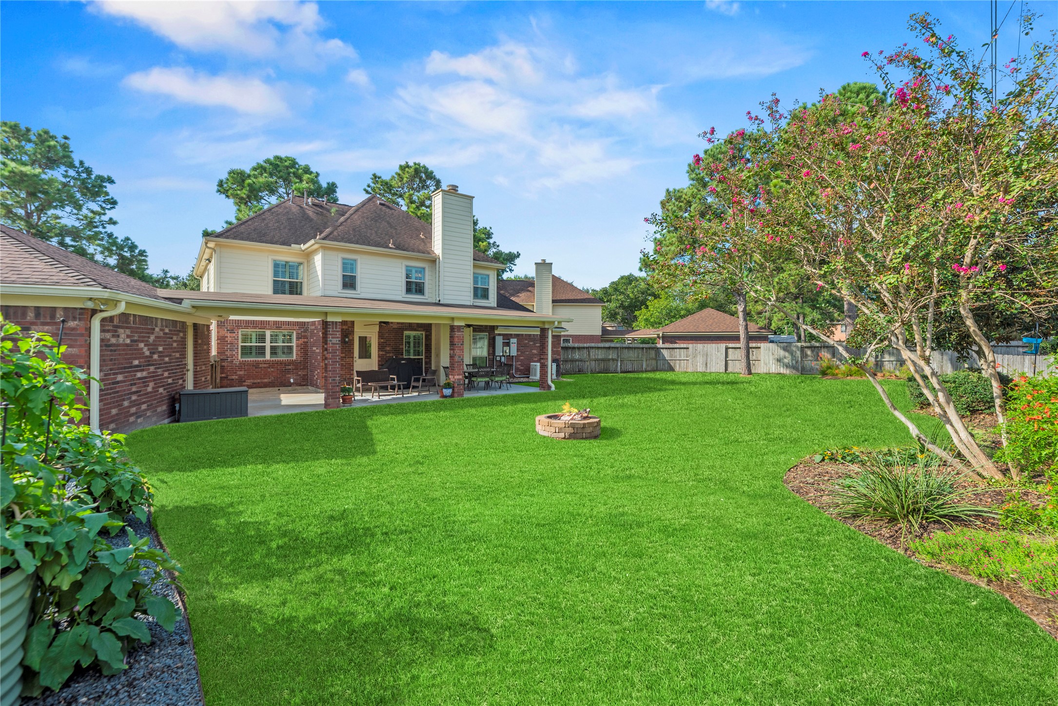 Step outside to a private backyard with a covered patio and a fire pit.