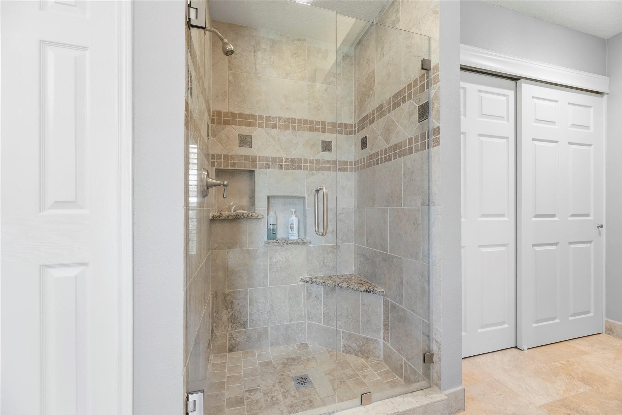 Frameless shower with a bench.