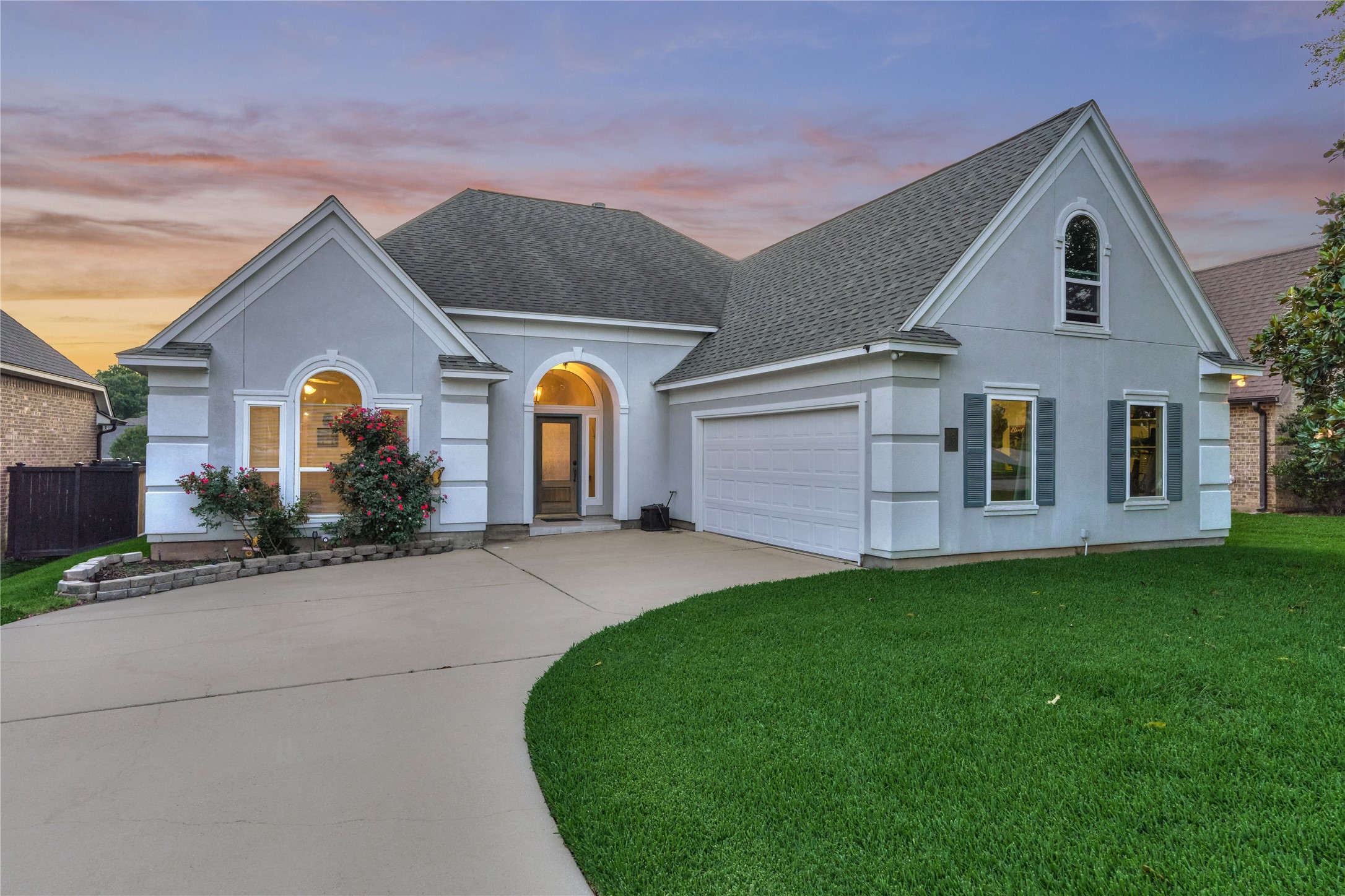 Elegant stucco exterior with a two-car garage and neatly manicured landscaping that creates beautiful, inviting curb appeal.