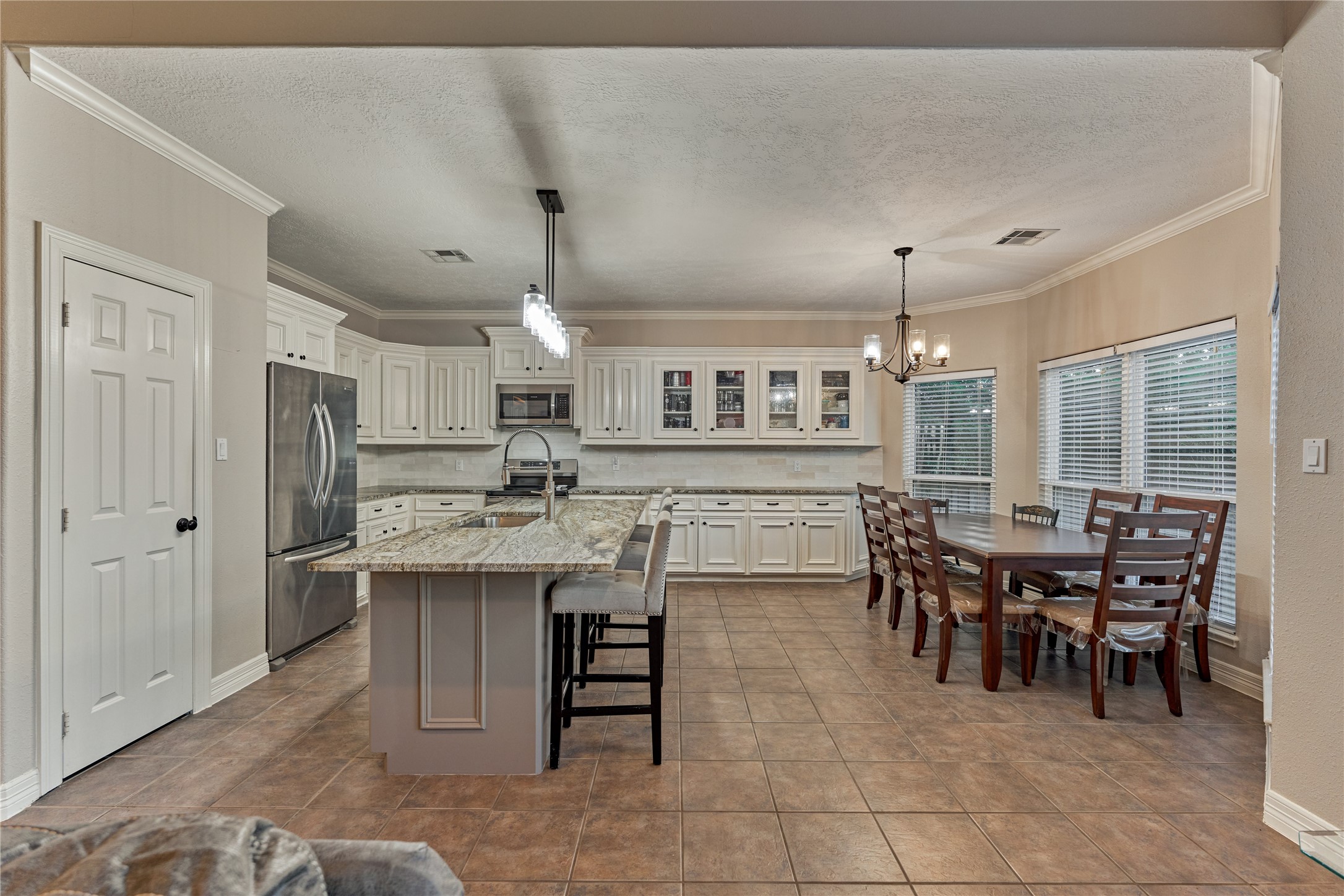 The beautifully updated kitchen opens seamlessly to the dining/breakfast room and living room, creating an inviting open-concept layout ideal for both everyday living and effortless entertaining.