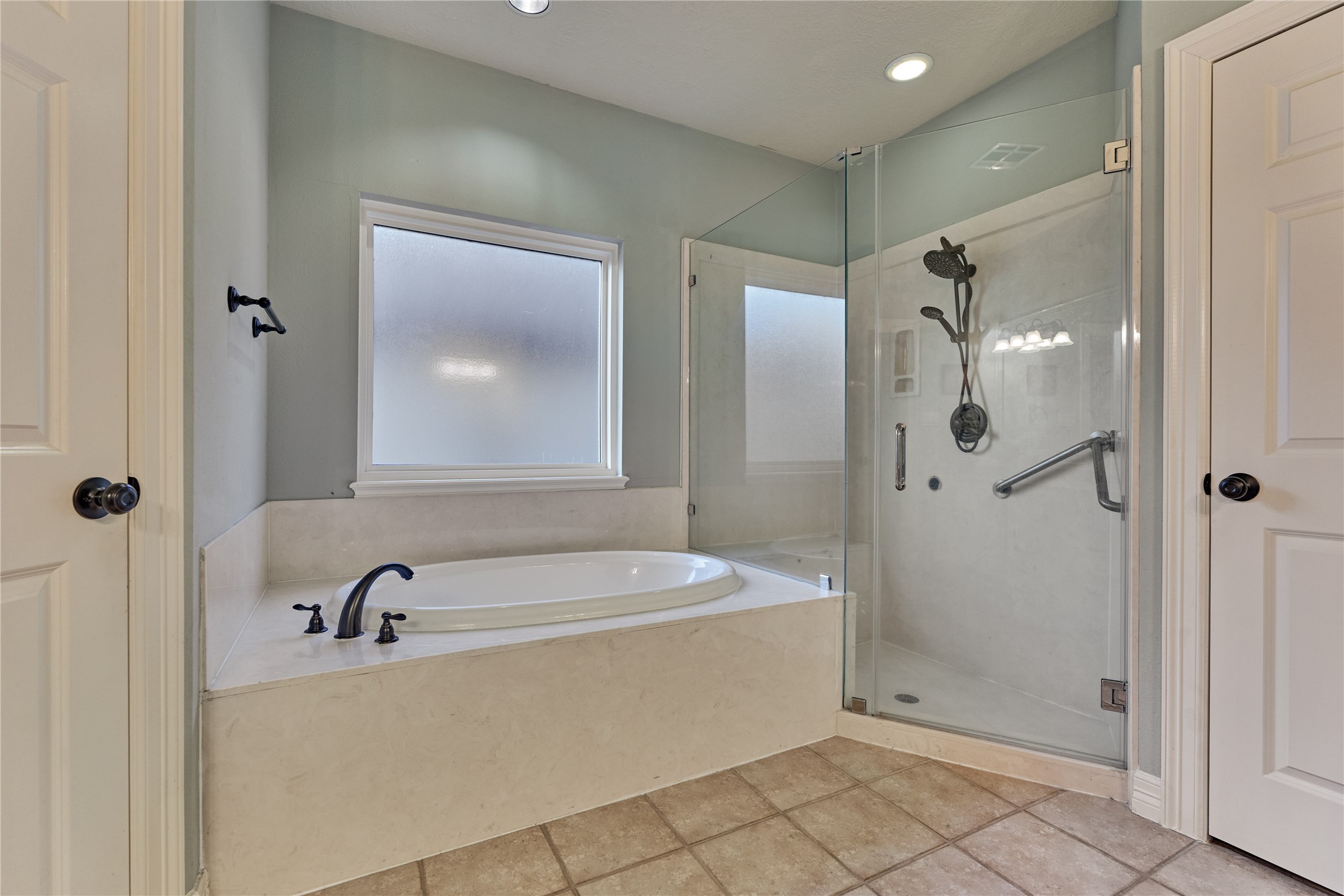 Enjoy a relaxing soak in the tub or step into the spacious walk-in shower with dual spray heads designed for a spa-inspired retreat.
