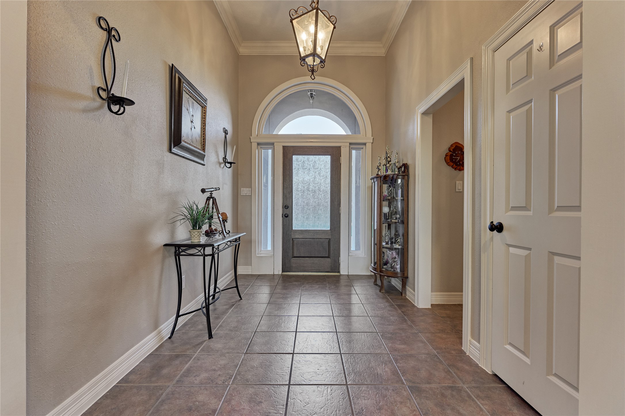 An elegant arched transom window above the entry door adds architectural charm while filling the foyer with soft natural light.