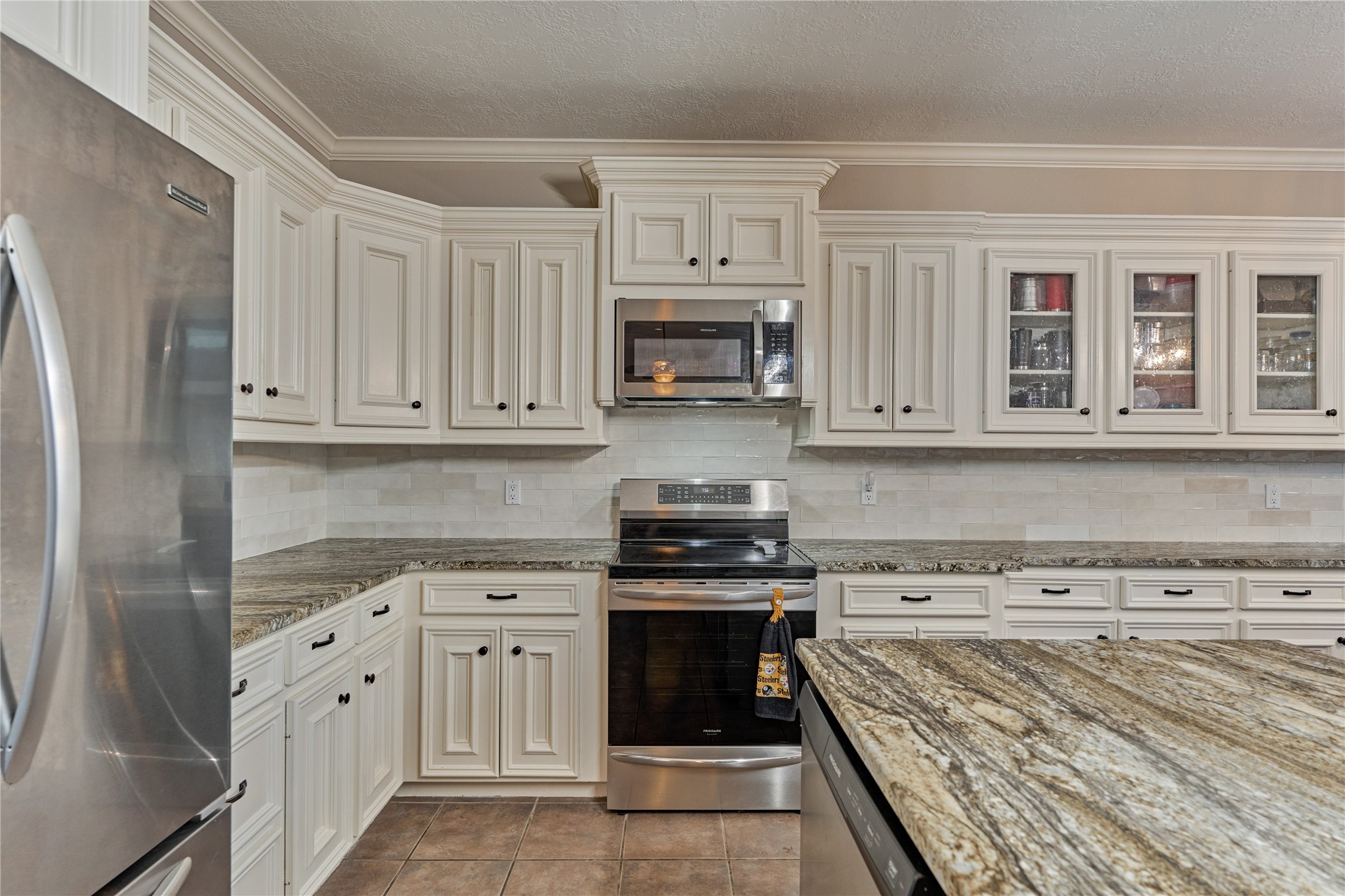 Sparkling stainless appliances complement the gorgeous granite countertops and sleek backsplash, creating a polished and functional chefs kitchen with both style and everyday convenience.