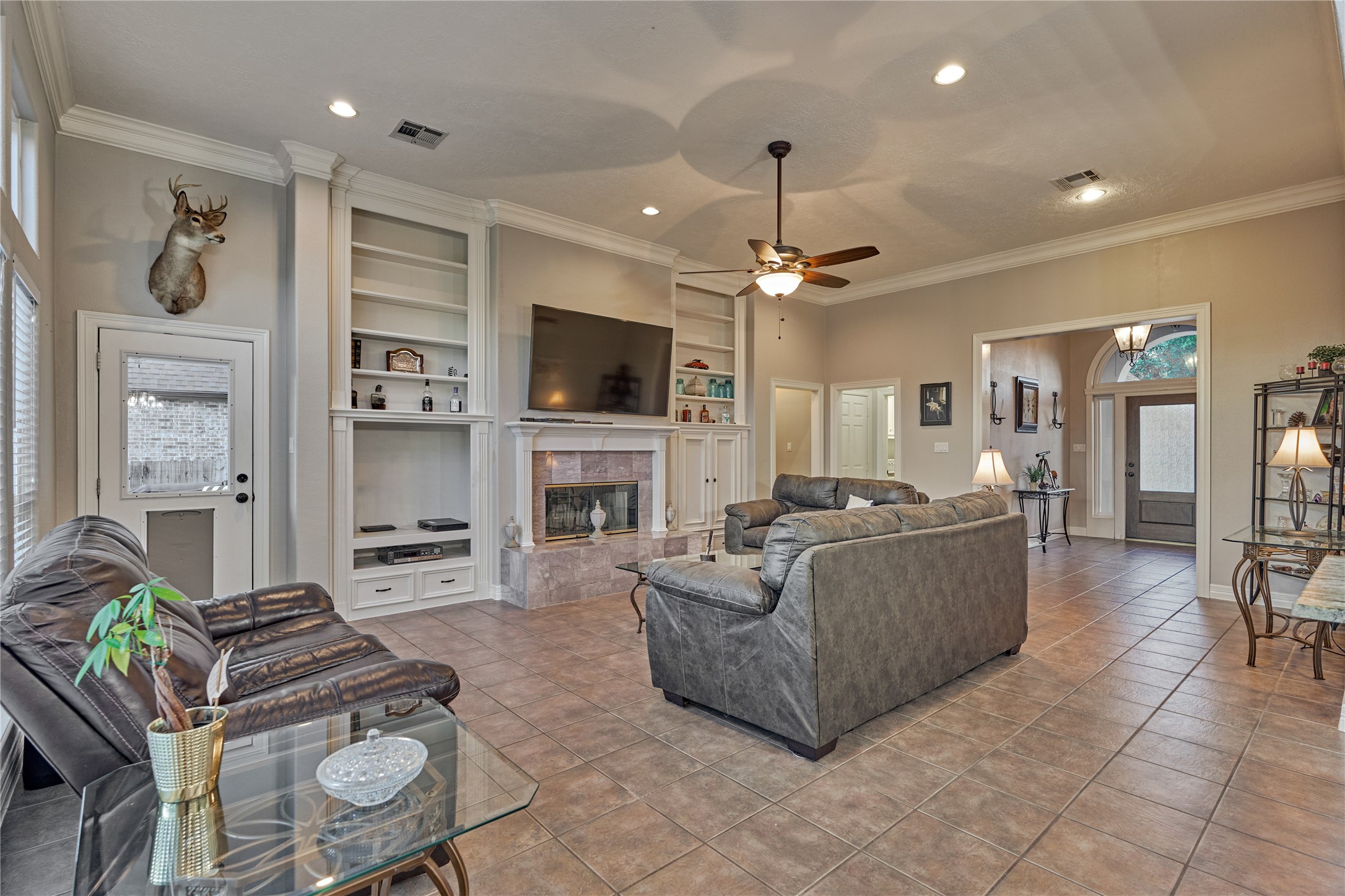 A warm, inviting fireplace is beautifully flanked by custom built-in cabinetry, creating both a cozy focal point and stylish storage.