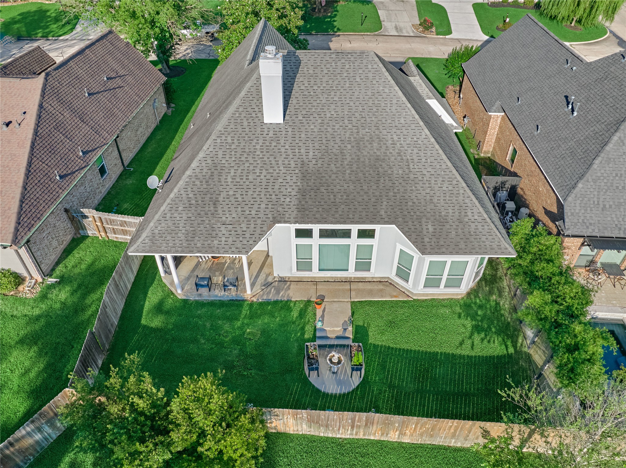 Backyard retreat features a covered patio, perfect for relaxing and entertaining guests year-round.