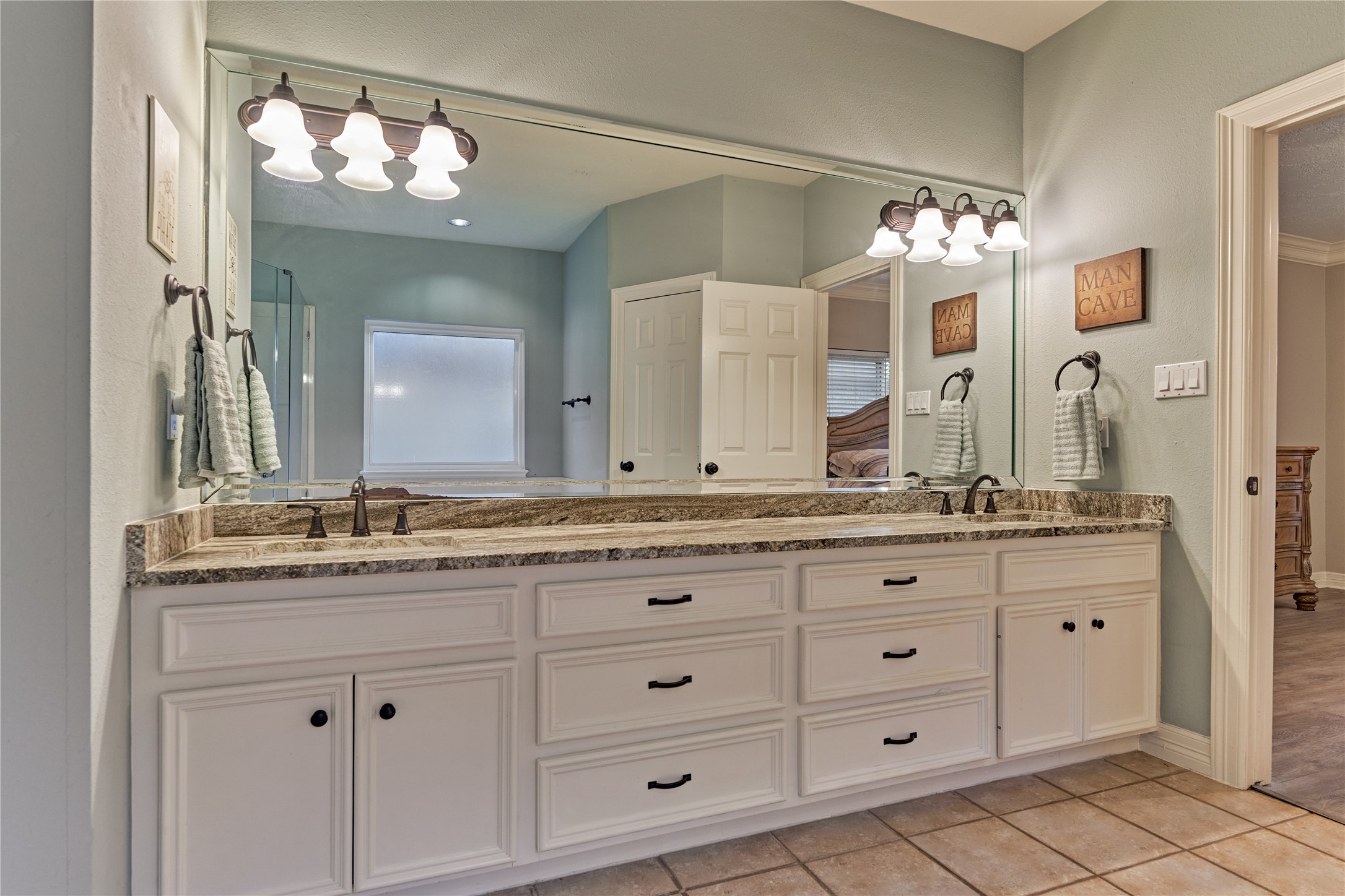 Dual sinks, stylish dual lighting, and an abundance of storage create both function and elegance in this well-appointed space.