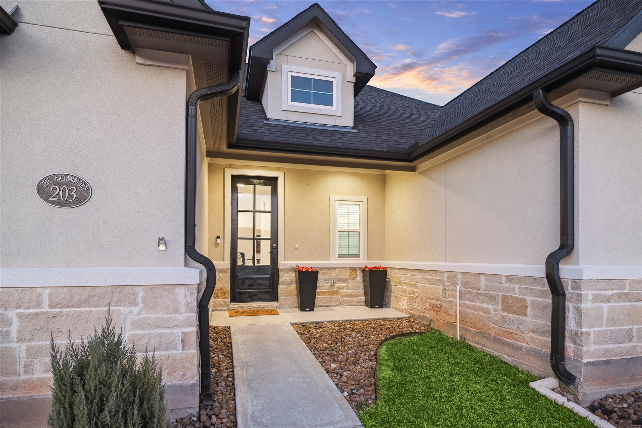 Welcome home to 203 Hampton Glen Road in the prestigious, private gated community of Bentwater on Lake Conroe.  A closer look at the welcoming front entry of this beautiful home. Curb appeal shines with a landscaped walkway, elegant black planters, and a charming dormer window that adds character to the faade. Step inside to discover a bright, open layout ideal for both everyday living and entertaining.