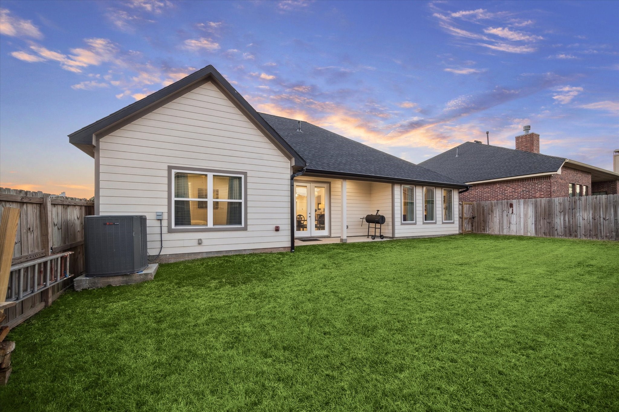 This angle of the patio provides a view of the property from the backyard, The double doors leading from the interior to the terrace allow for abundant natural light indoors and offer easy access for larger items, combining style, convenience, and functionality.