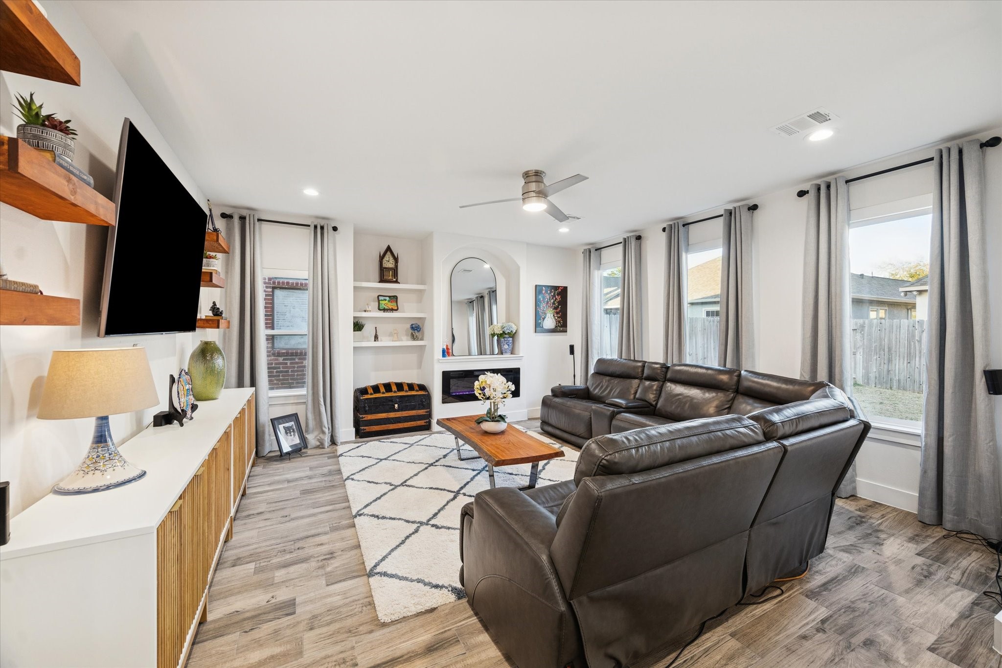 Youll love this spacious living room, a cozy yet open space ideal for entertaining and creating quality memories with loved ones around the fireplace. The flooring has been recently updated to wood-like tile, offering the beauty of hardwood with the added convenience of easy cleaning and low maintenance.