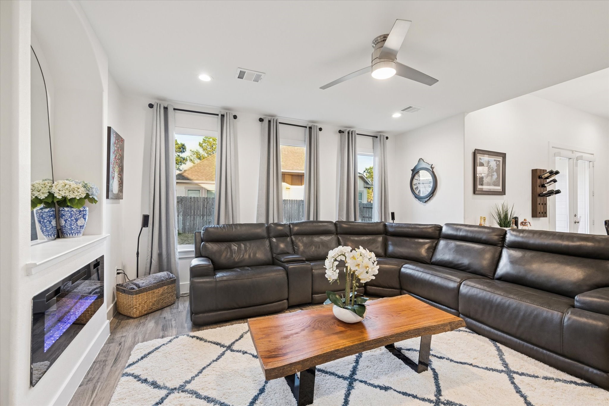 This view of the living room showcases the abundant natural light flowing through the windows, enhancing the homes warm and inviting feel. A comfortable and serene space, ideal for unwinding on the sofa and enjoying quality time with family after a long day.