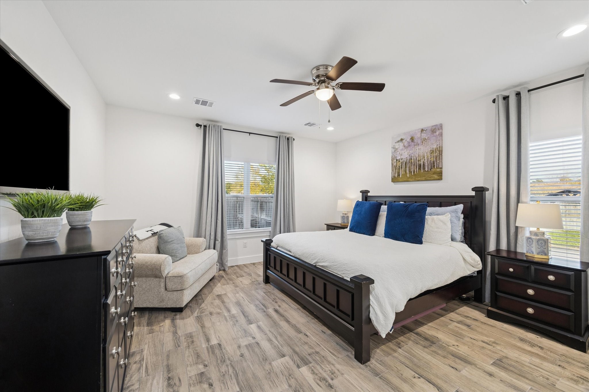 This view of the primary bedroom highlights an elegant, light-filled space. Spacious enough to accommodate all your bedroom furniture, it creates a serene retreat for rest and relaxation. The soft, light wall tones enhance the sense of calm and openness, while energy-efficient LED lighting adds both functionality and convenience.