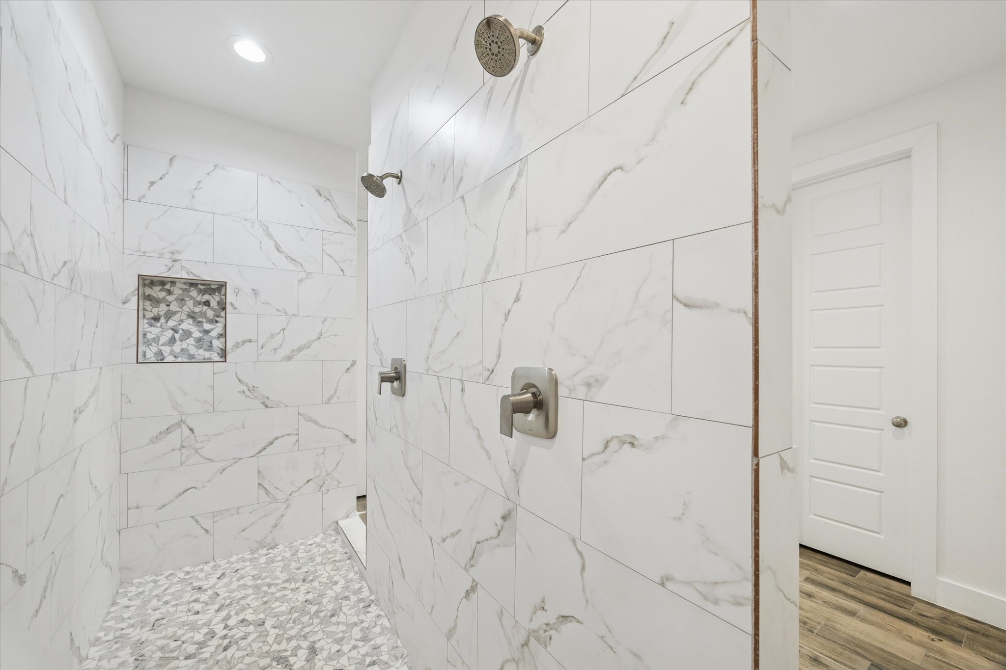 The ensuite shower offers a spacious and comfortable layout, featuring dual shower heads for added convenience. Subtle lighting enhances the space without compromising privacy, creating a bright, inviting, and luxurious shower experience.