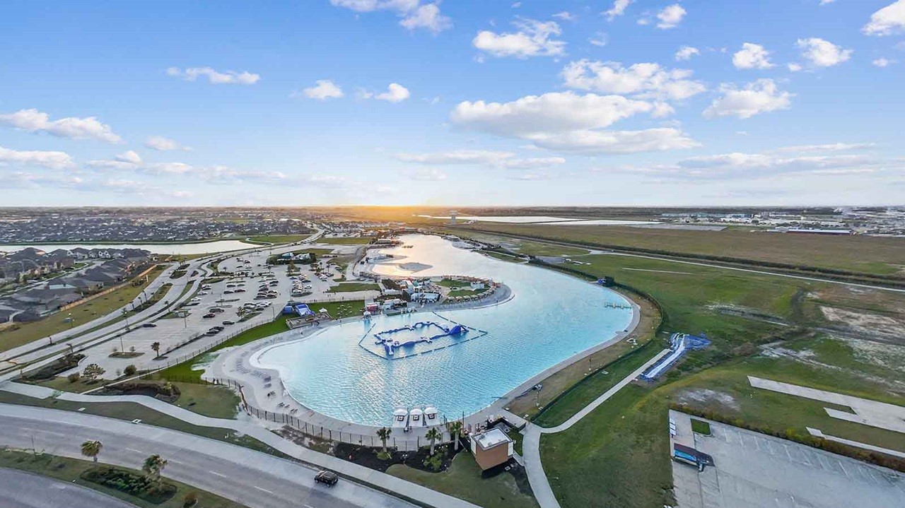 Aerial view of the communities crystal lagoon with sandy beaches and waterfront recreation