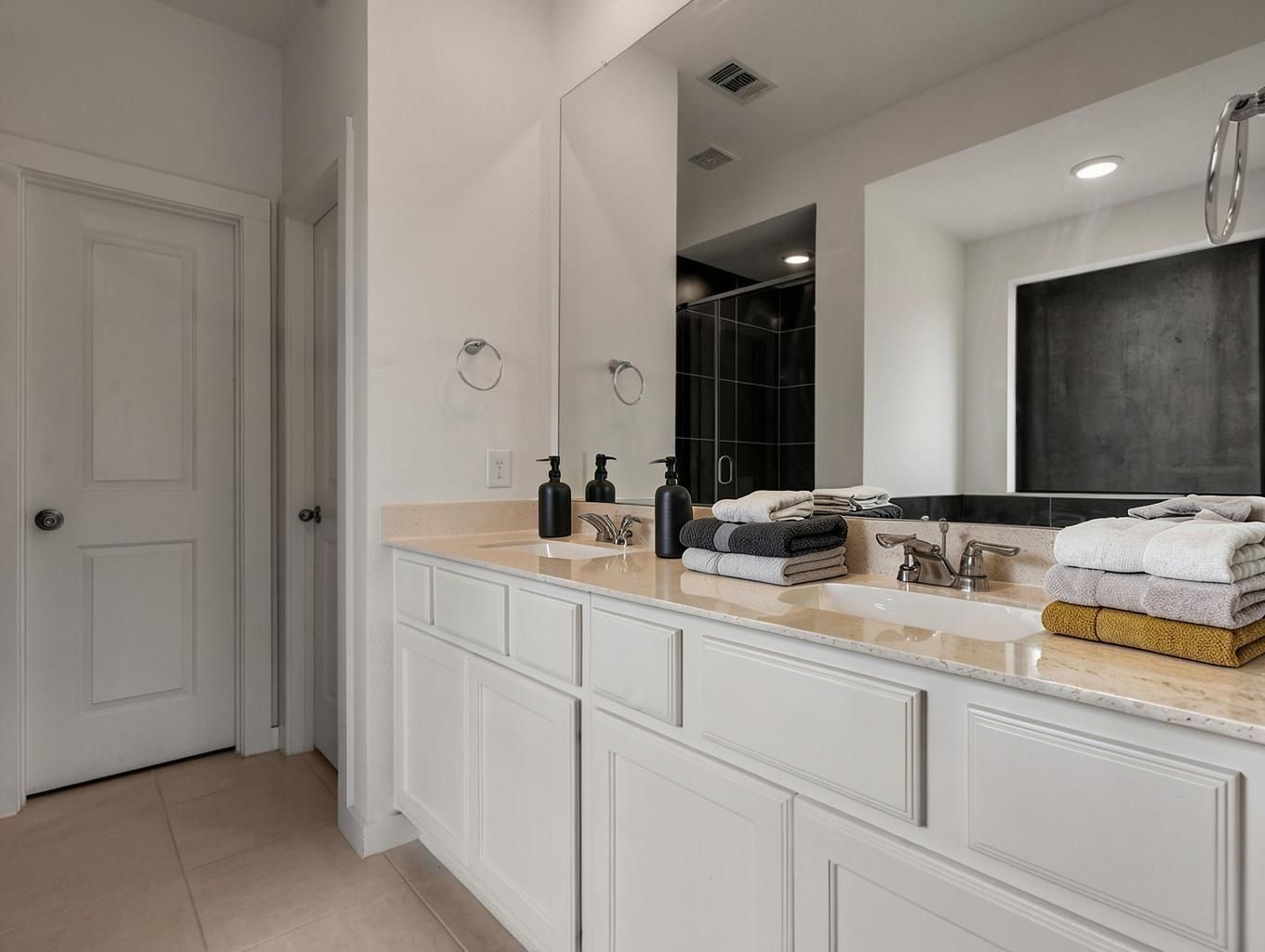 The primary bath features double sinks, bright counters, and clean cabinetry. A fresh ensuite space with a crisp, polished finish. Virtually staged.