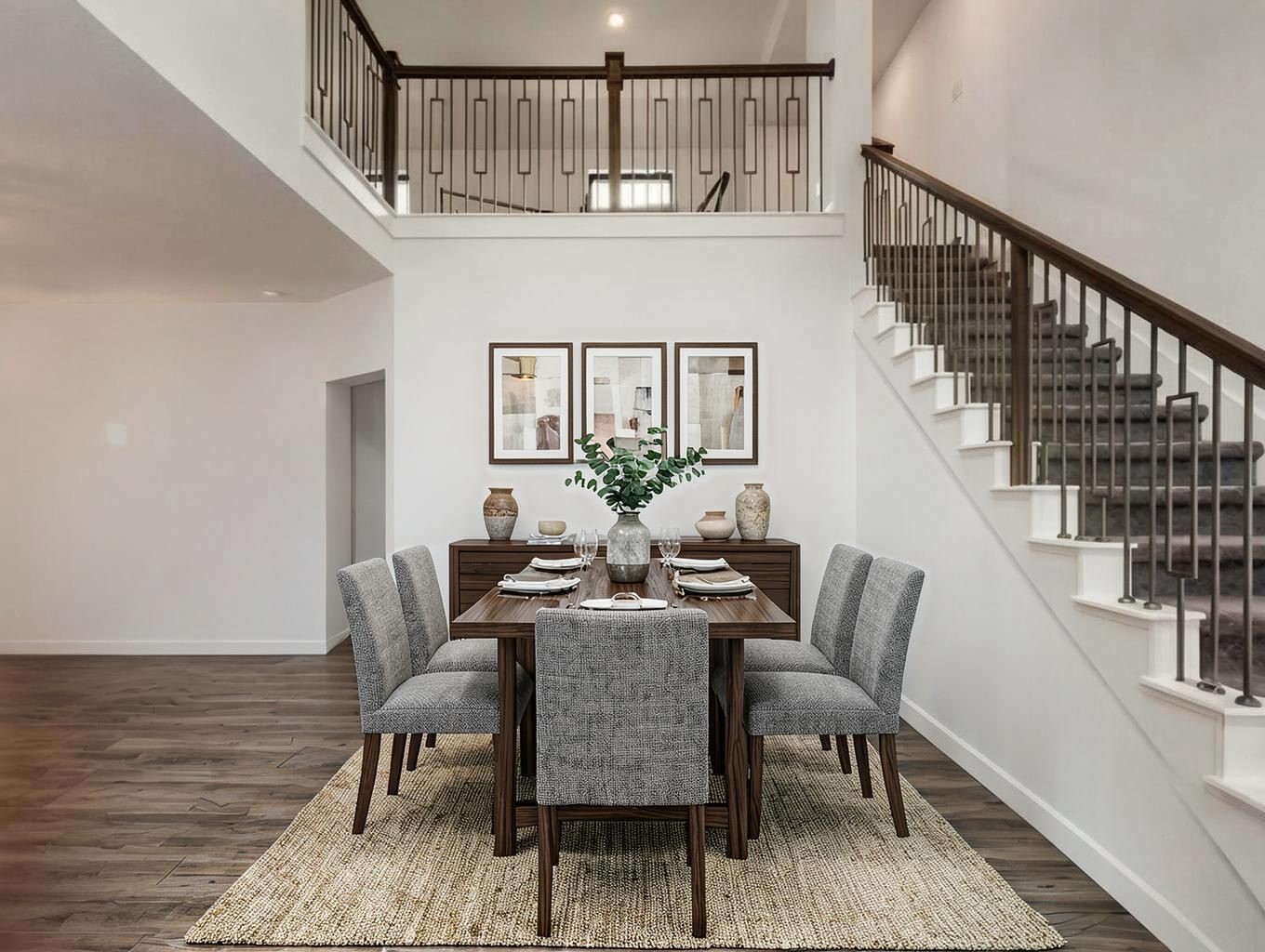The dining area is framed by the staircase and open living layout, giving it a strong sense of place. It feels elegant without being overdone. Virtually staged.