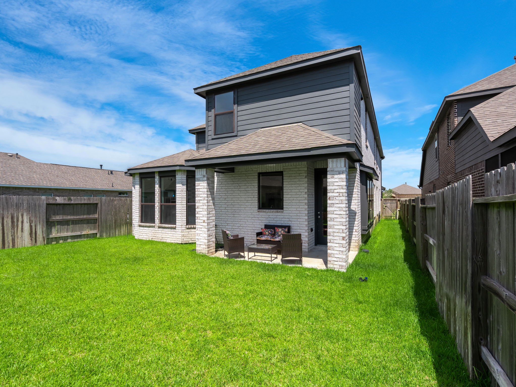 The backyard offers a fenced lawn with a covered patio and clean rear elevation. A quiet outdoor space with simple, usable appeal. Virtually staged.