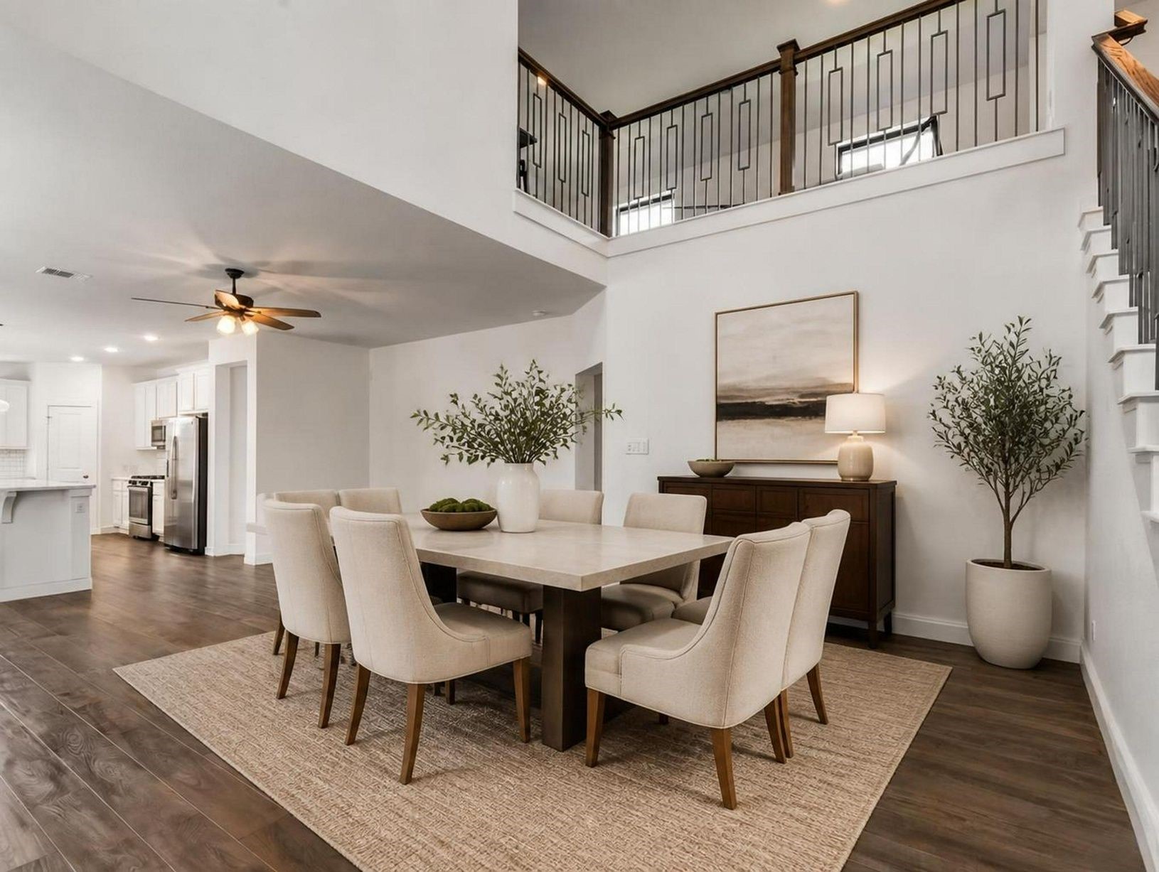 The dining area sits beautifully beneath the staircase, giving the main level a defined place to gather. Clean lines and soft finishes make the space feel polished. Virtually staged.
