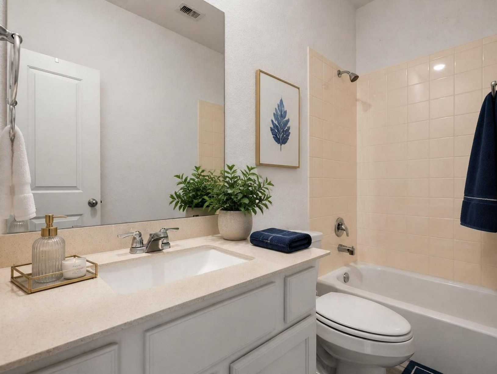 The secondary bathroom offers a clean tub/shower setup with bright finishes and practical storage. Simple, polished, and easy to use. Virtually staged.