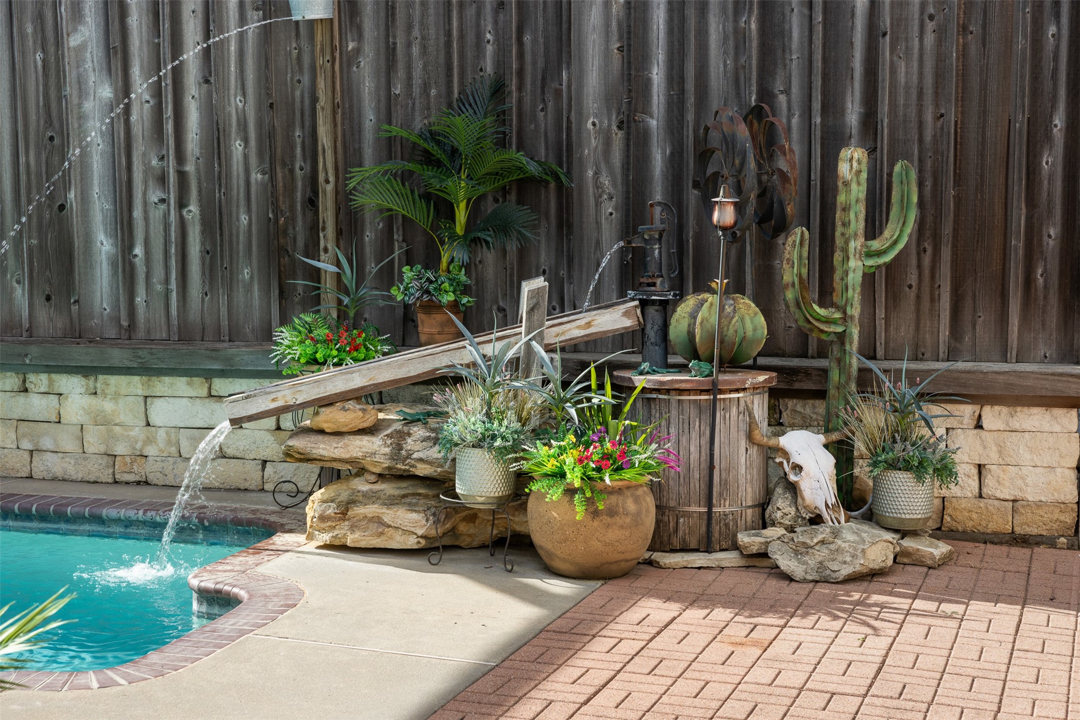 A whimsical waterfall feature adds tranquility to the pool area.