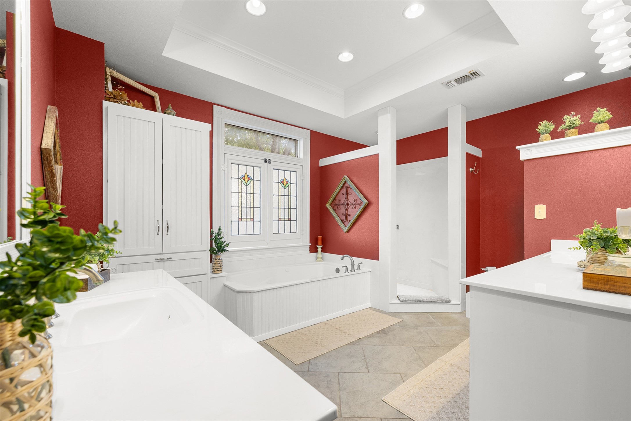 The spacious primary bath offers a jetted tub, separate shower and a dramatic red-and-white palette.