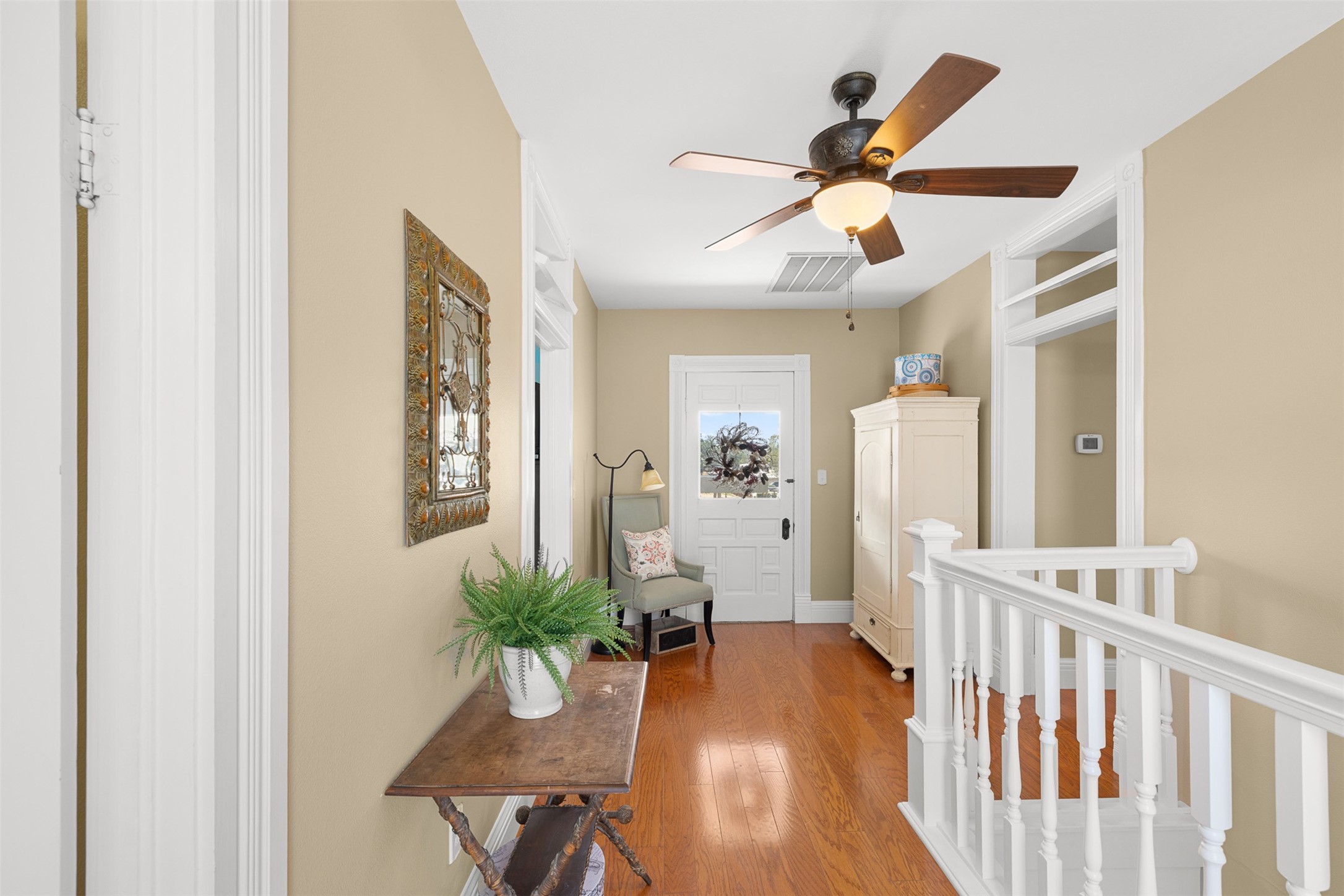 The upstairs landing connects the secondary bedrooms and opens toward the homes sweeping upper balcony.