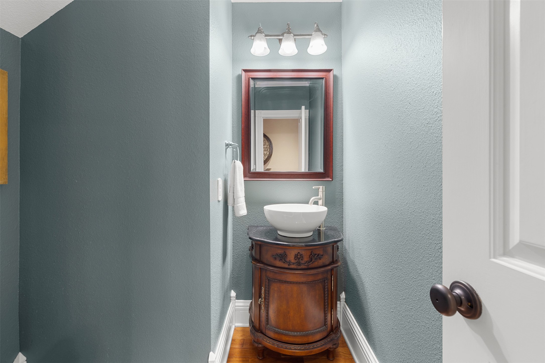 Tucked beneath the staircase, the charming powder room makes clever use of the homes historic floor plan.