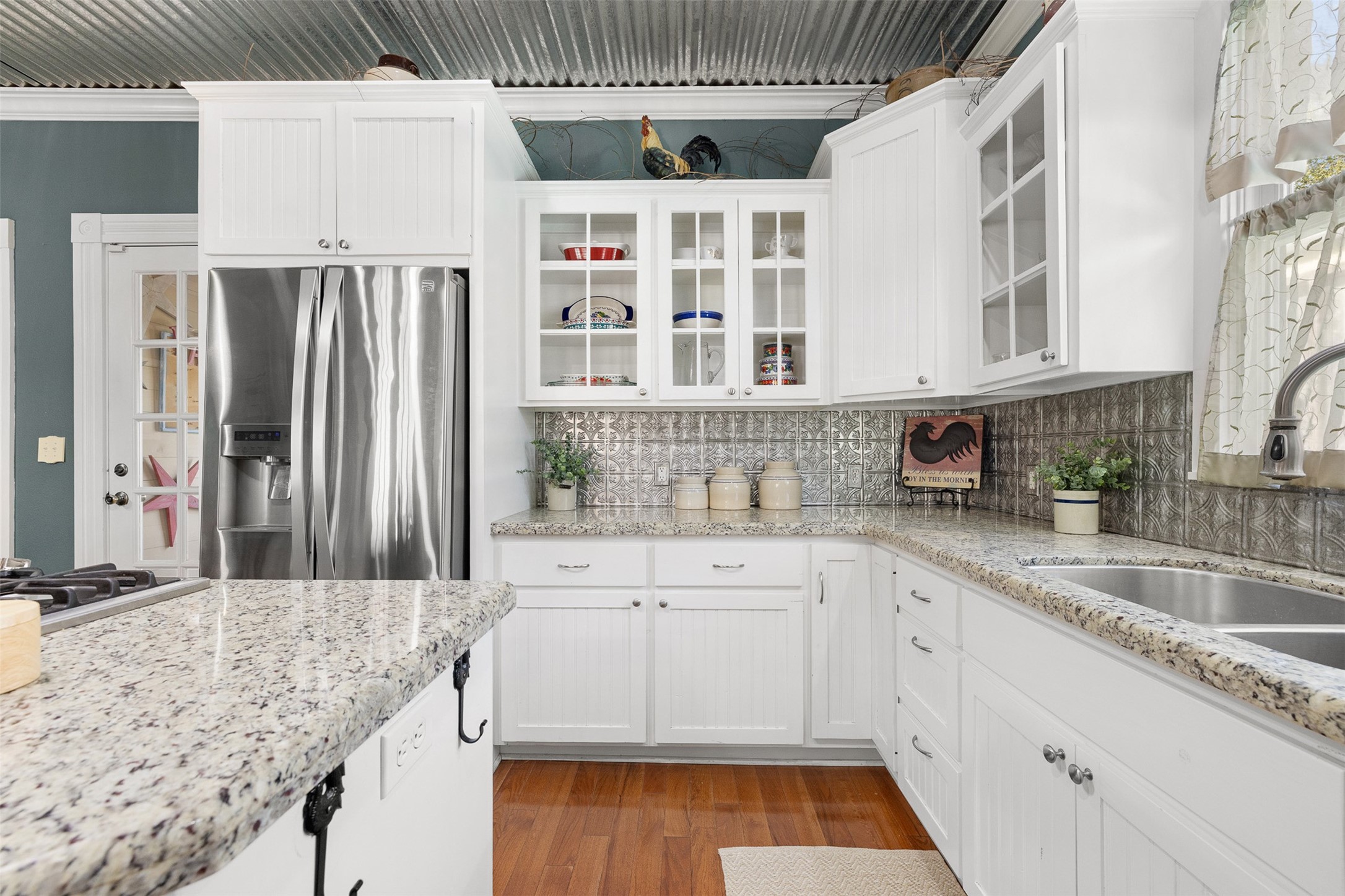 Glass-front cabinetry, granite surfaces and thoughtful storage bring style and function to the updated kitchen.