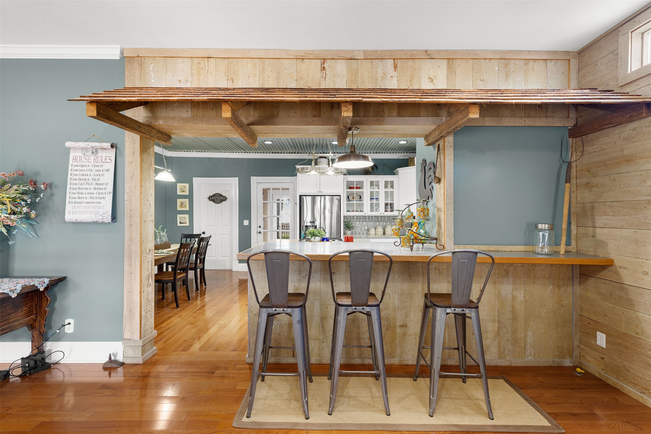 A character-filled bar fashioned from original wood, nails and cheesecloth connects the family room with the dining and kitchen areas.