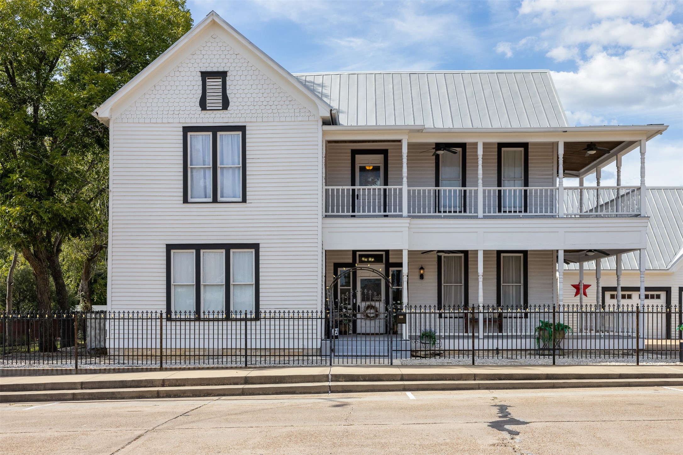 Graceful double porches, classic black-and-white styling and a wrought-iron fence create an unforgettable first impression.