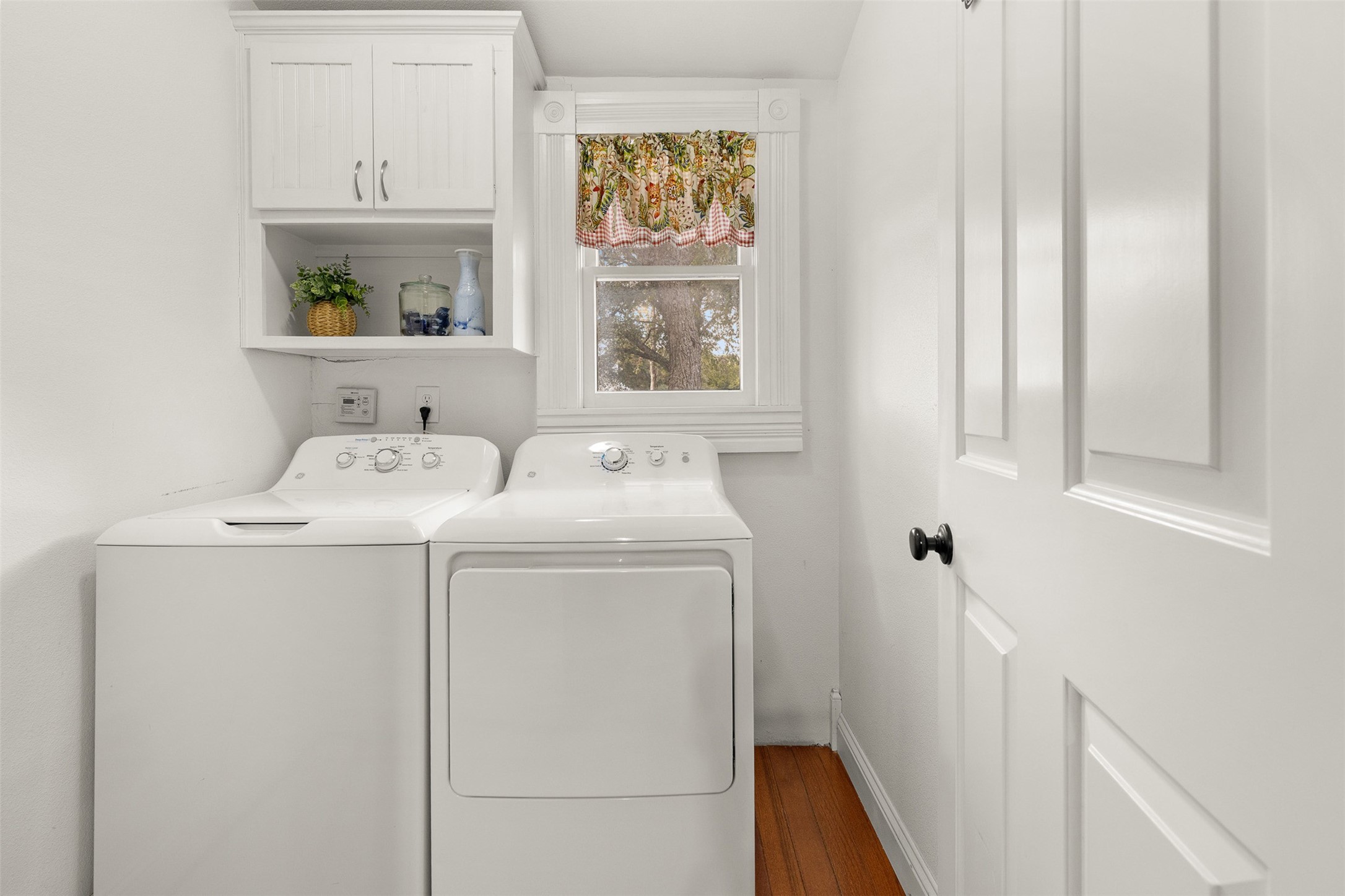 The dedicated utility room offers built-in cabinetry and convenient in-home laundry space.