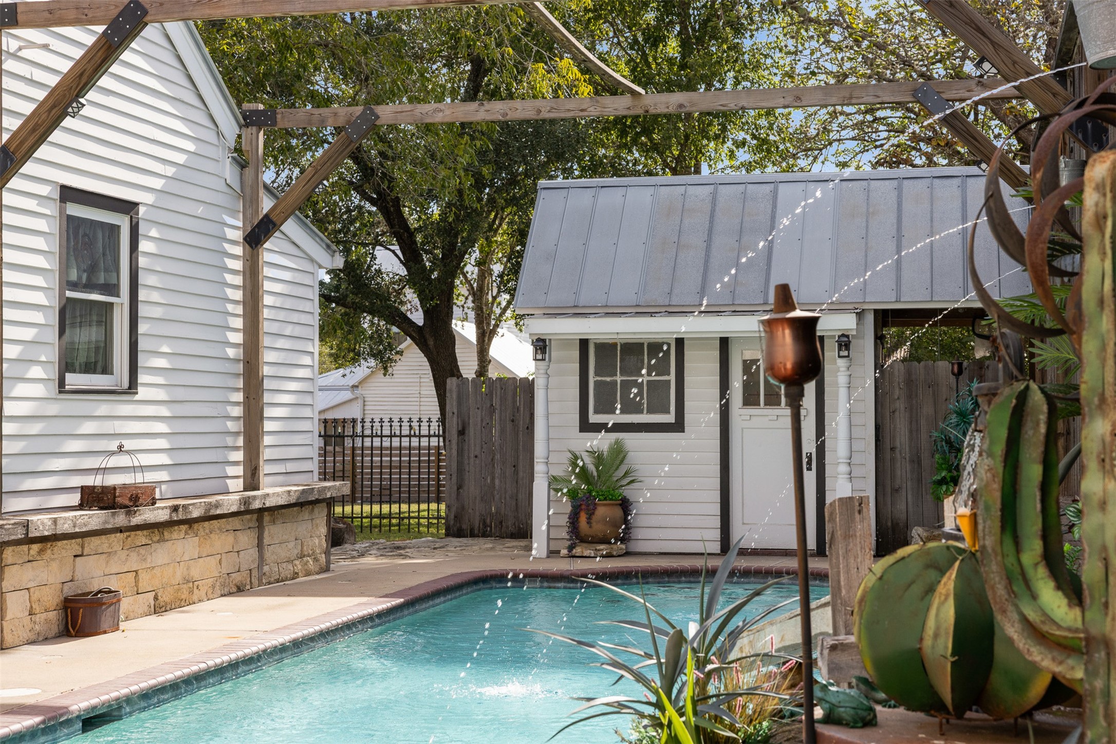 The pool house adds convenience and character to this inviting backyard escape.