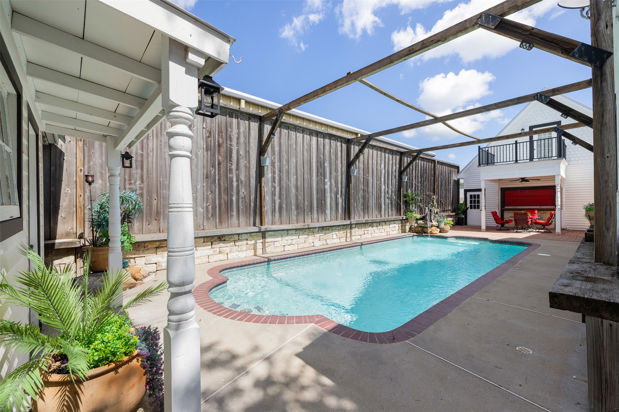 The private in-ground pool creates a refreshing retreat surrounded by fencing and outdoor living spaces.
