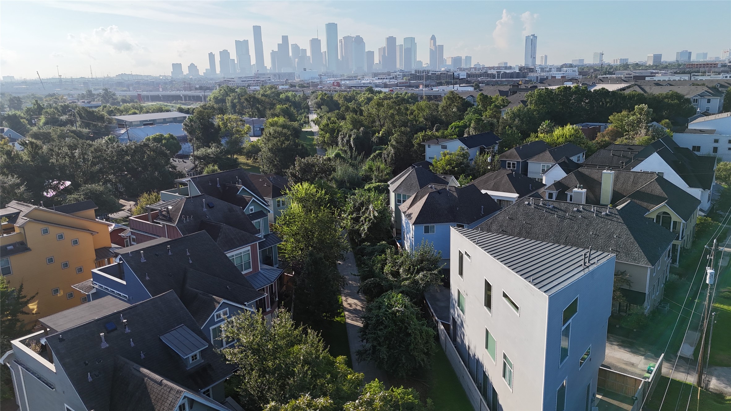 Downtown Houston rises just beyond the neighborhood, showcasing the Heights close connection to the city center while maintaining its tree lined residential setting.