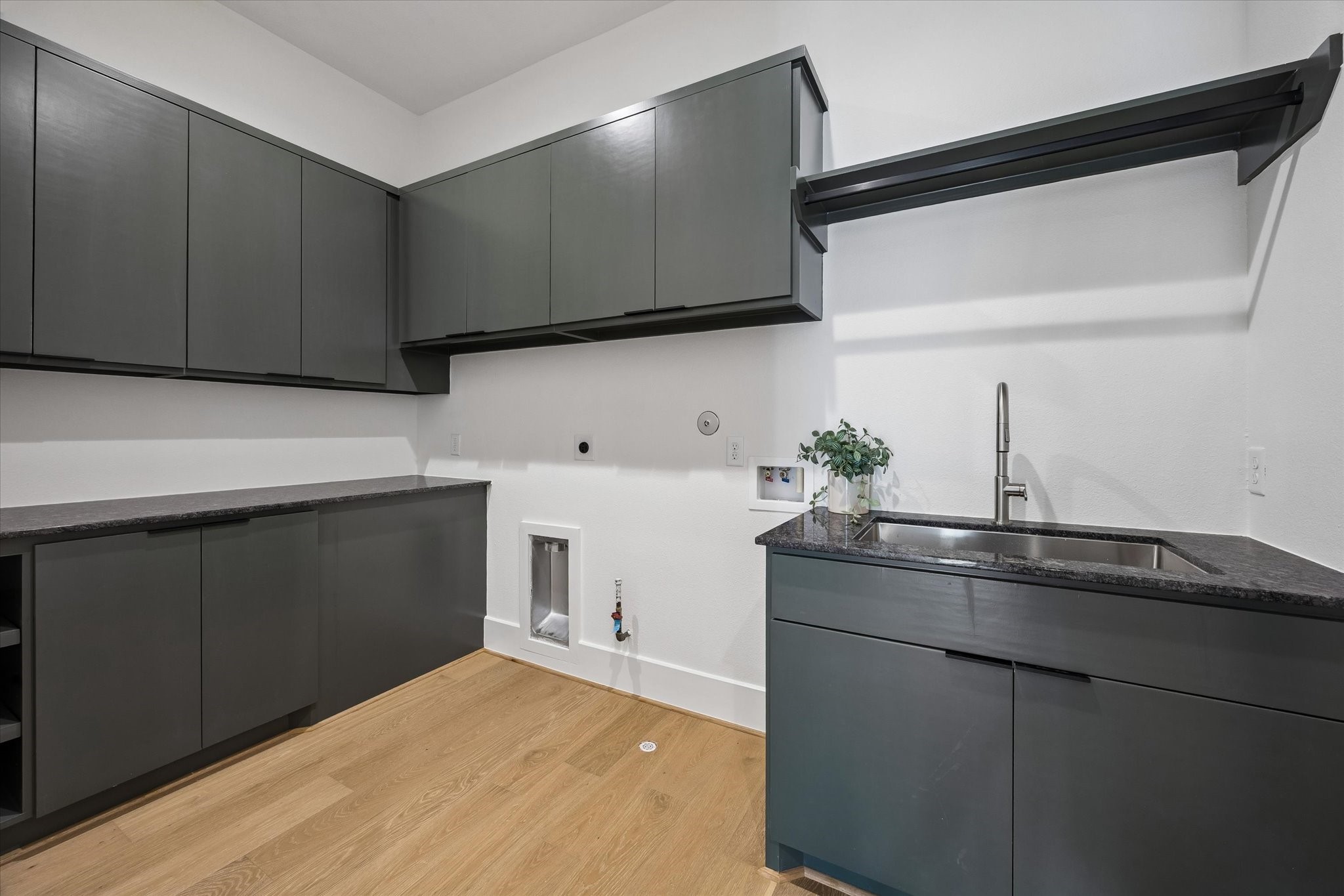 Designed with everyday organization in mind, the utility room pairs extensive cabinetry with generous counter space, a utility sink and dedicated hanging space.