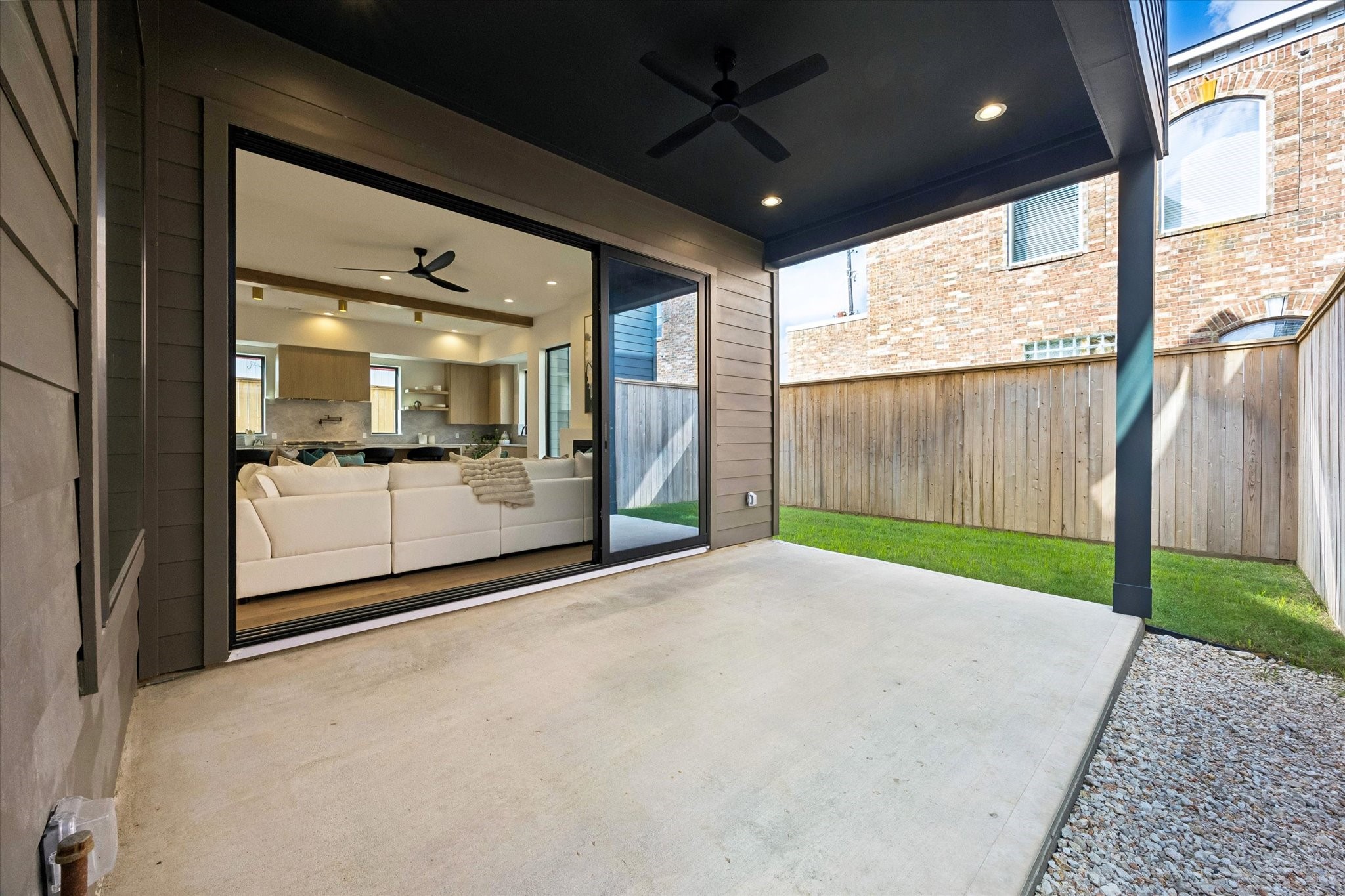 Covered patio extends the living space outdoors, with recessed lighting, a ceiling fan and wide sliding glass doors creating an easy connection to the main living area.