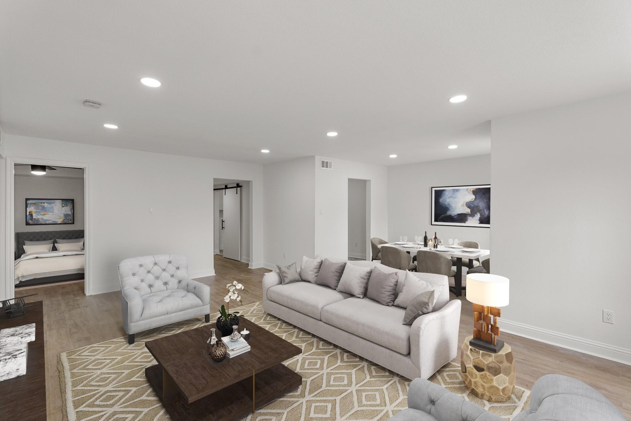 Spacious and modern living area with elegant recessed lighting, comfortable seating, and an open layout leading to a cozy dining space. Spacious and modern living area with elegant recessed lighting, comfortable seating, and an open layout leading to a cozy dining space.
