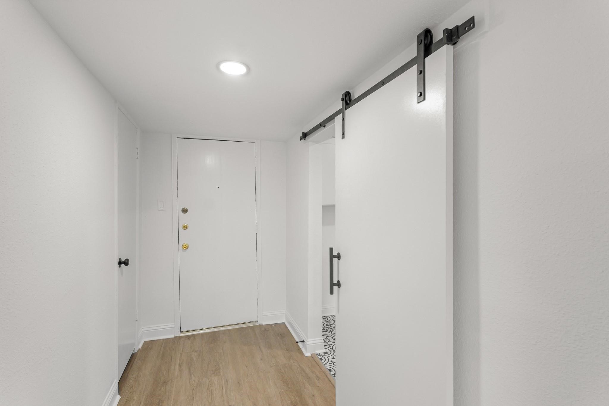 Bright entryway featuring sleek barn door and stylish vinyl plank flooring, offering a modern touch to this welcoming space. Bright entryway featuring sleek barn door and stylish vinyl plank flooring, offering a modern touch to this welcoming space.