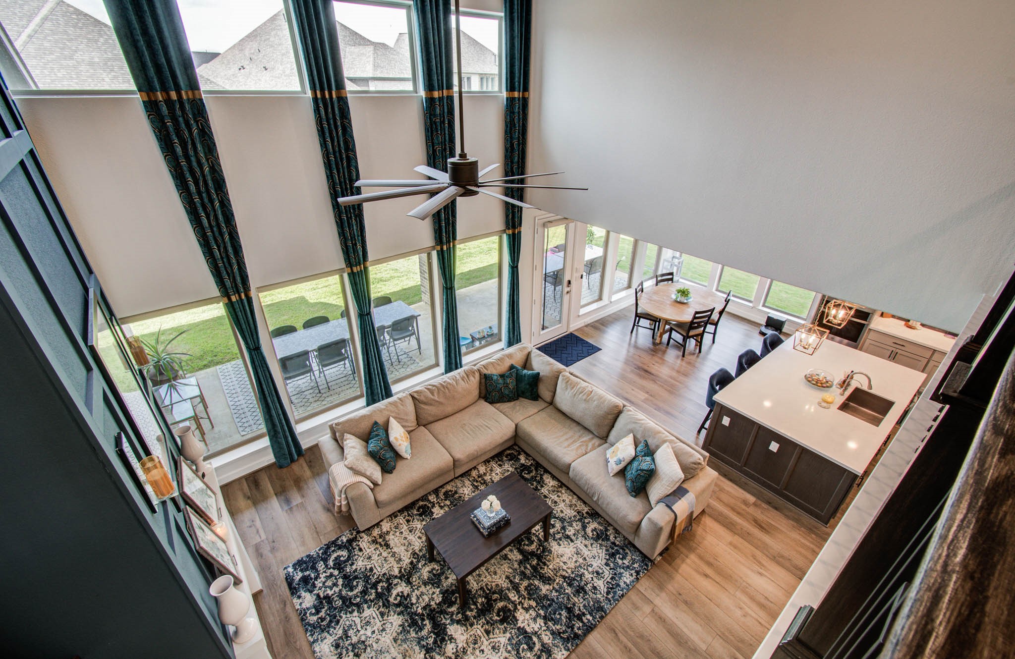 Experience the perfect blend of space and style in this open-concept living area, featuring high ceilings and abundant natural light from floor-to-ceiling windows, seamlessly connecting to a modern kitchen and inviting dining space, ideal for family gatherings and entertaining.