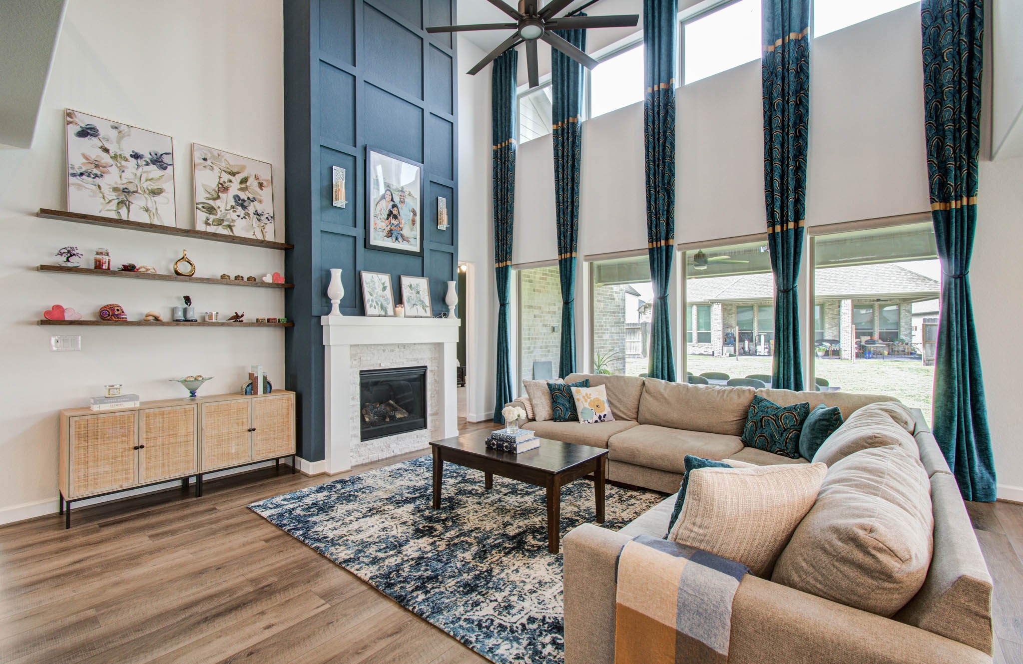Experience luxury and convenience in this elegant living room, where soaring ceilings and abundant natural light are complemented by sleek electric roller shades for effortless ambiance control.