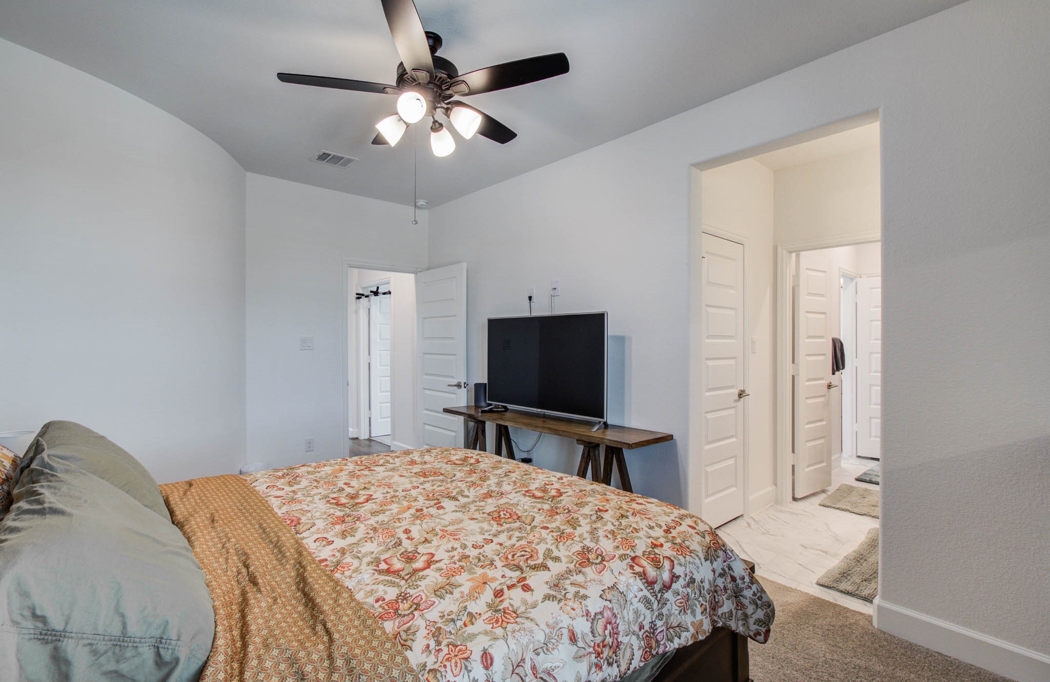 Secondary bedroom up with ceiling fan and roller shades. This room has it own bath.