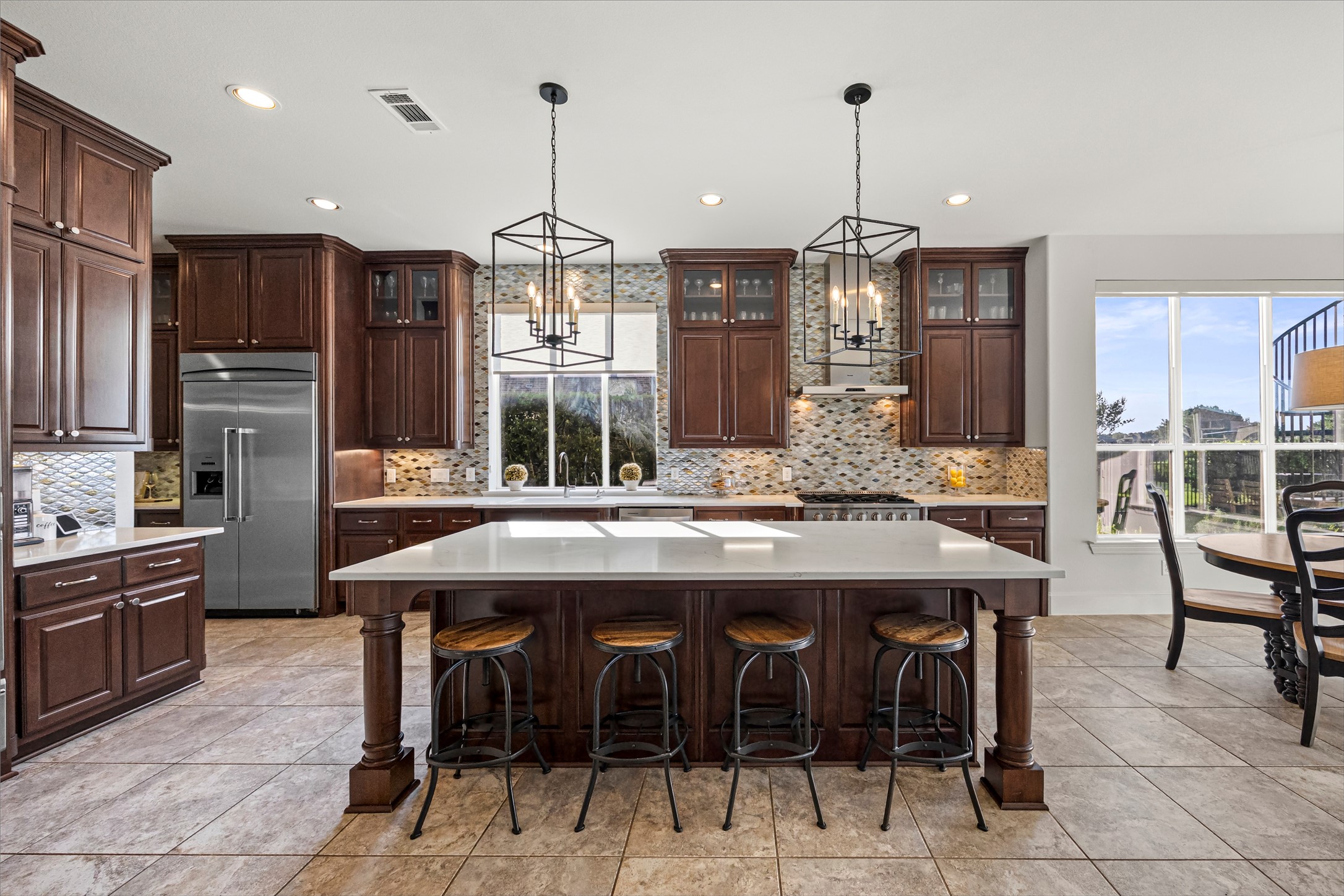 Kitchen with island seating, stainless steel appliances, and generous counter space. New quartz countertops and backsplash (2024). Kegerator and 2 beverage dispensers.