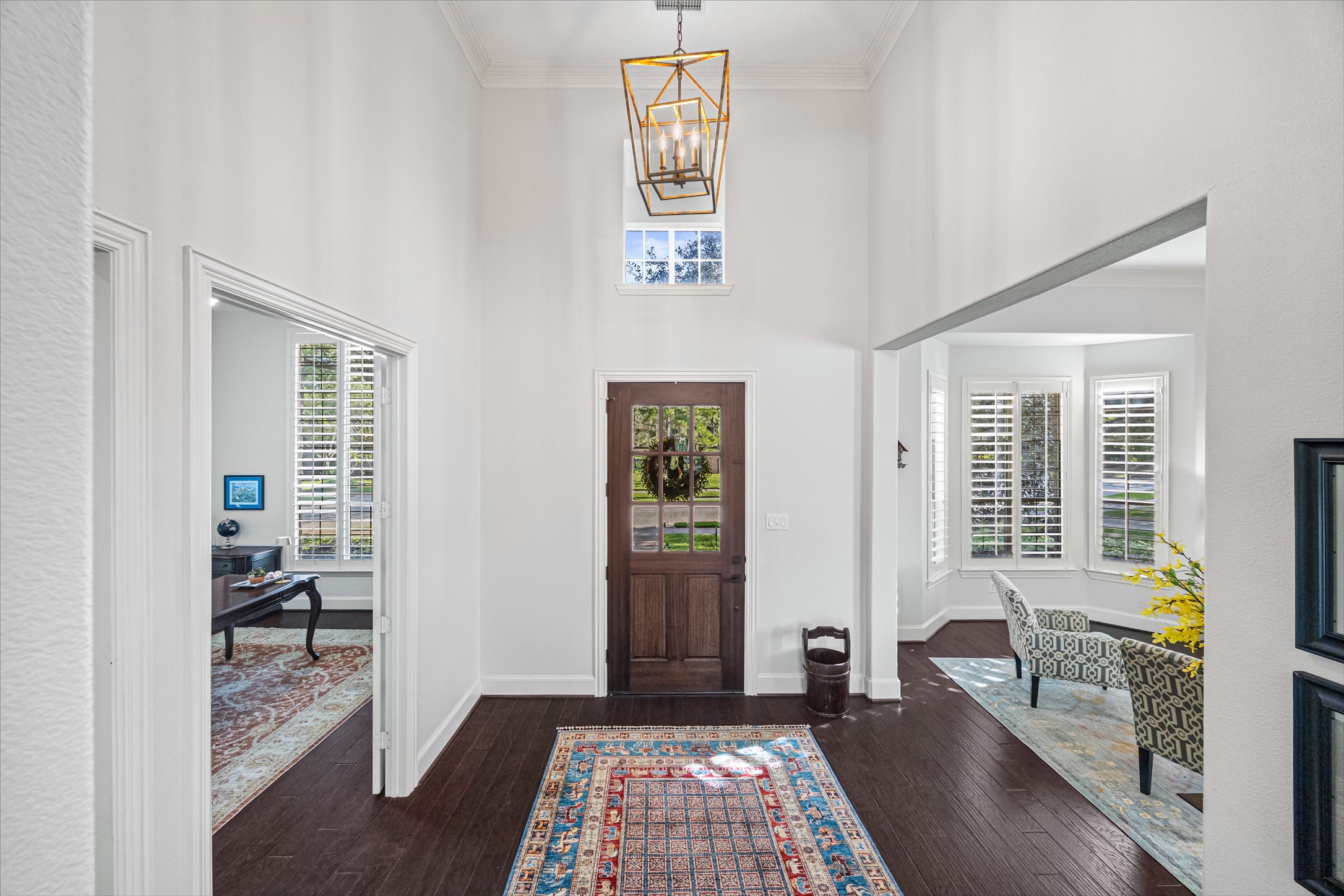 Dramatic foyer with soaring ceilings, statement chandelier, and rich dark flooring opening to formal spaces. All new lighting on dimmers. Updated paint throughout.