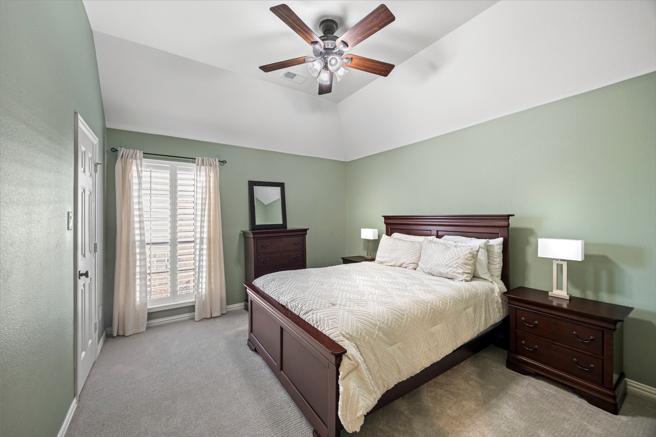 Comfortable bedroom with ceiling fan and plush carpet.