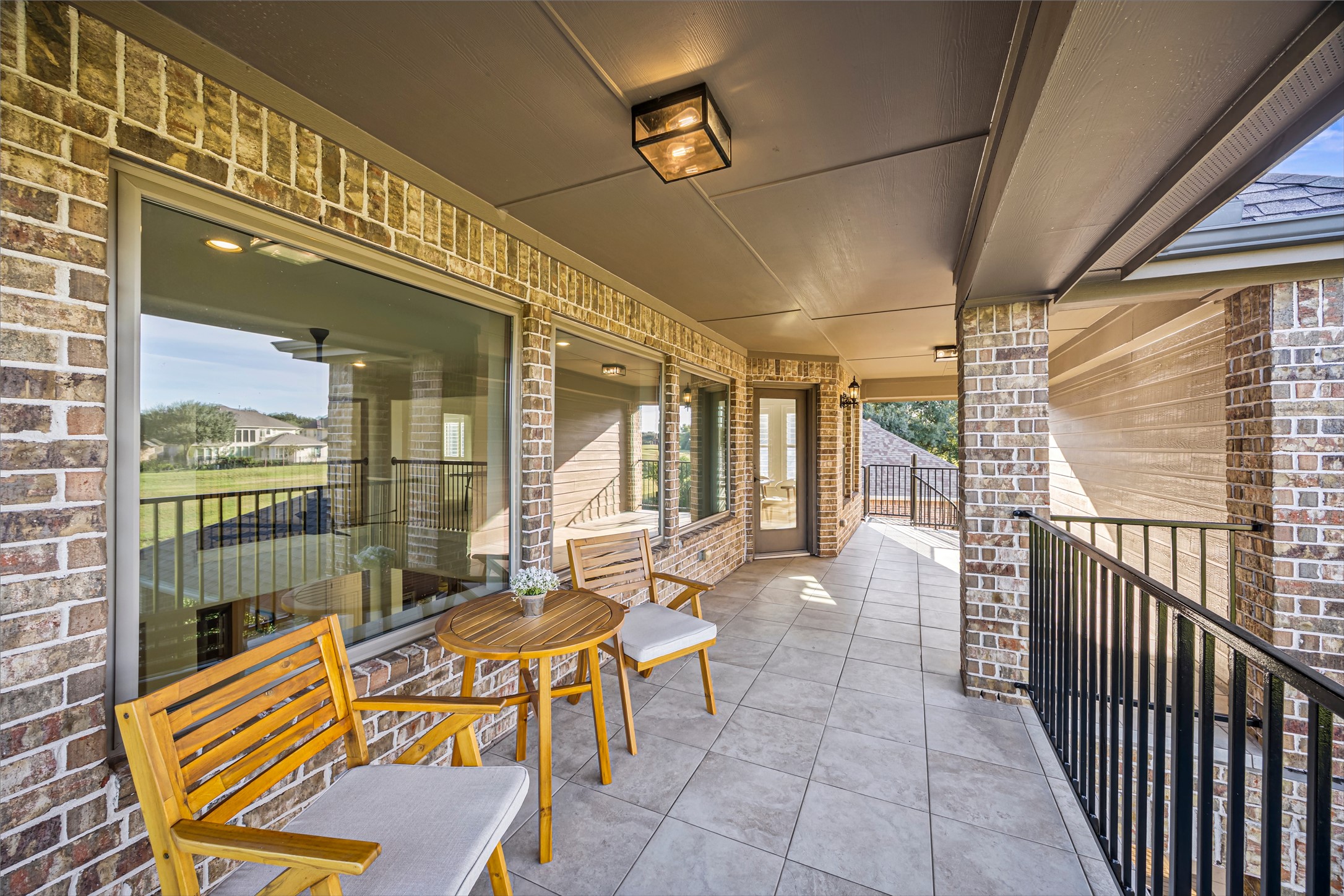 Covered balcony with outdoor seating overlooking the grounds