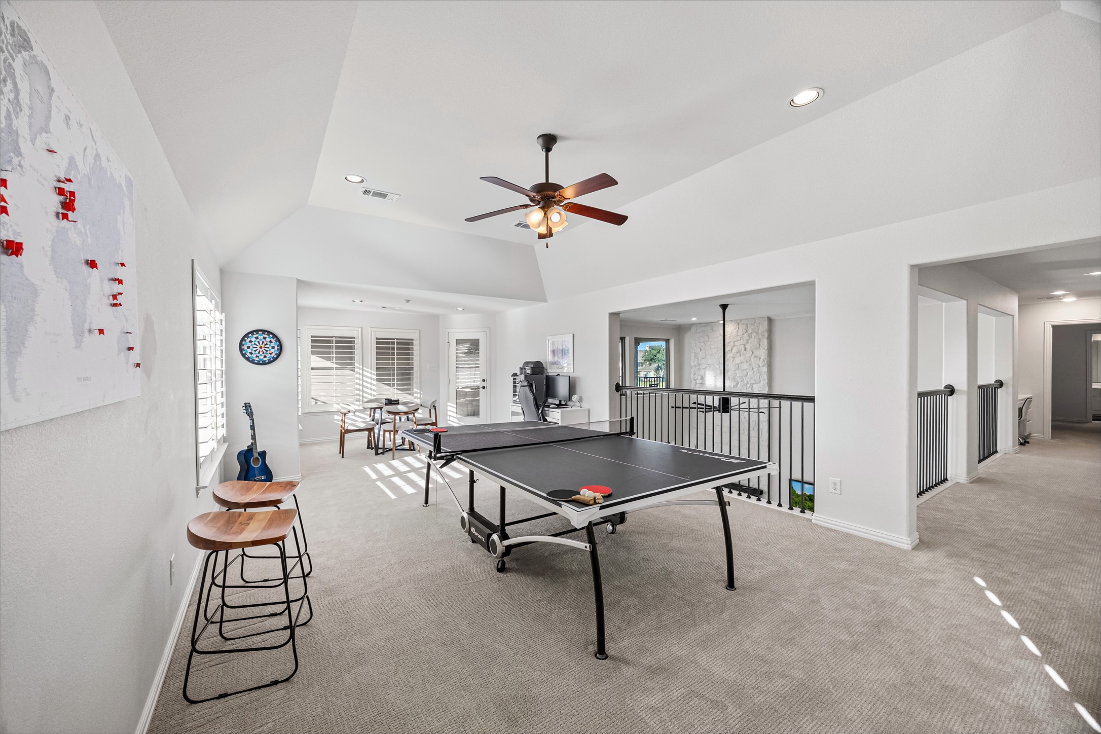 Expansive game room with ceiling fan and abundant natural light.
